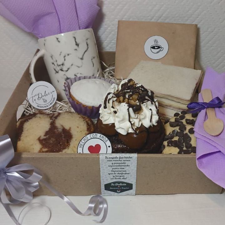 Una caja llena de una variedad de postres y una servilleta morada.