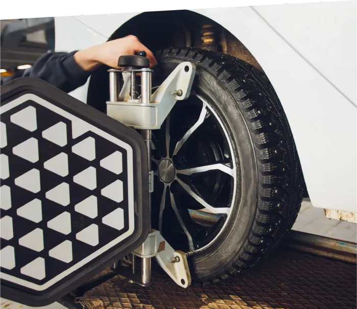 Electrician inspecting electrical panel, holding tablet, wearing hard hat and safety glasses.