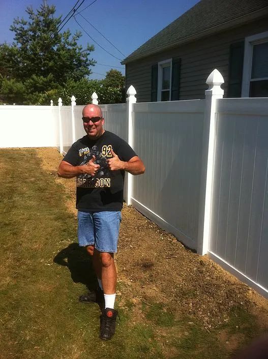 Man Standing Next To Fence