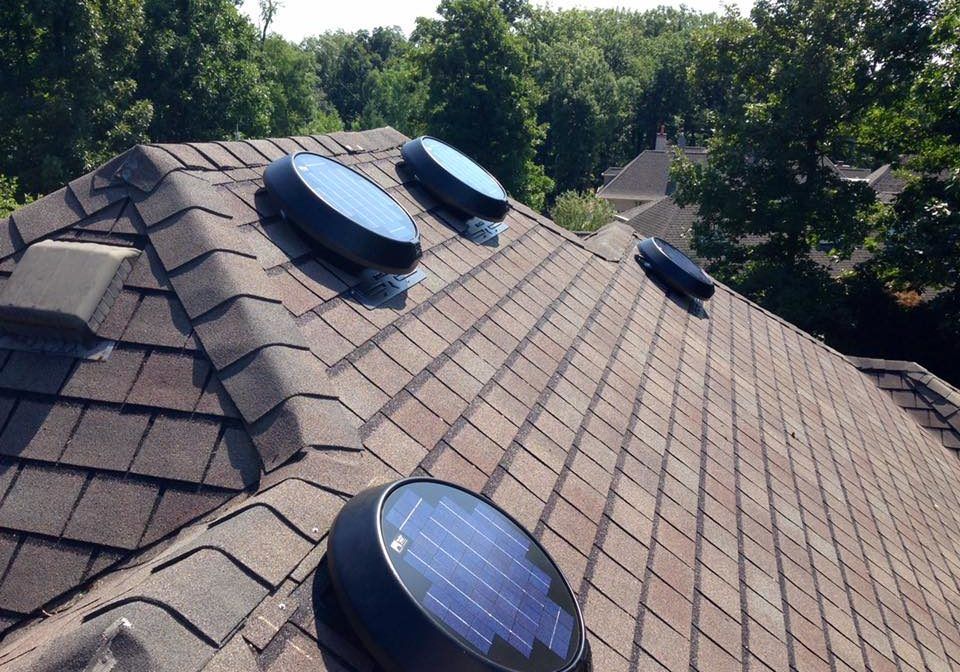 a roof with a fan and solar panels on it