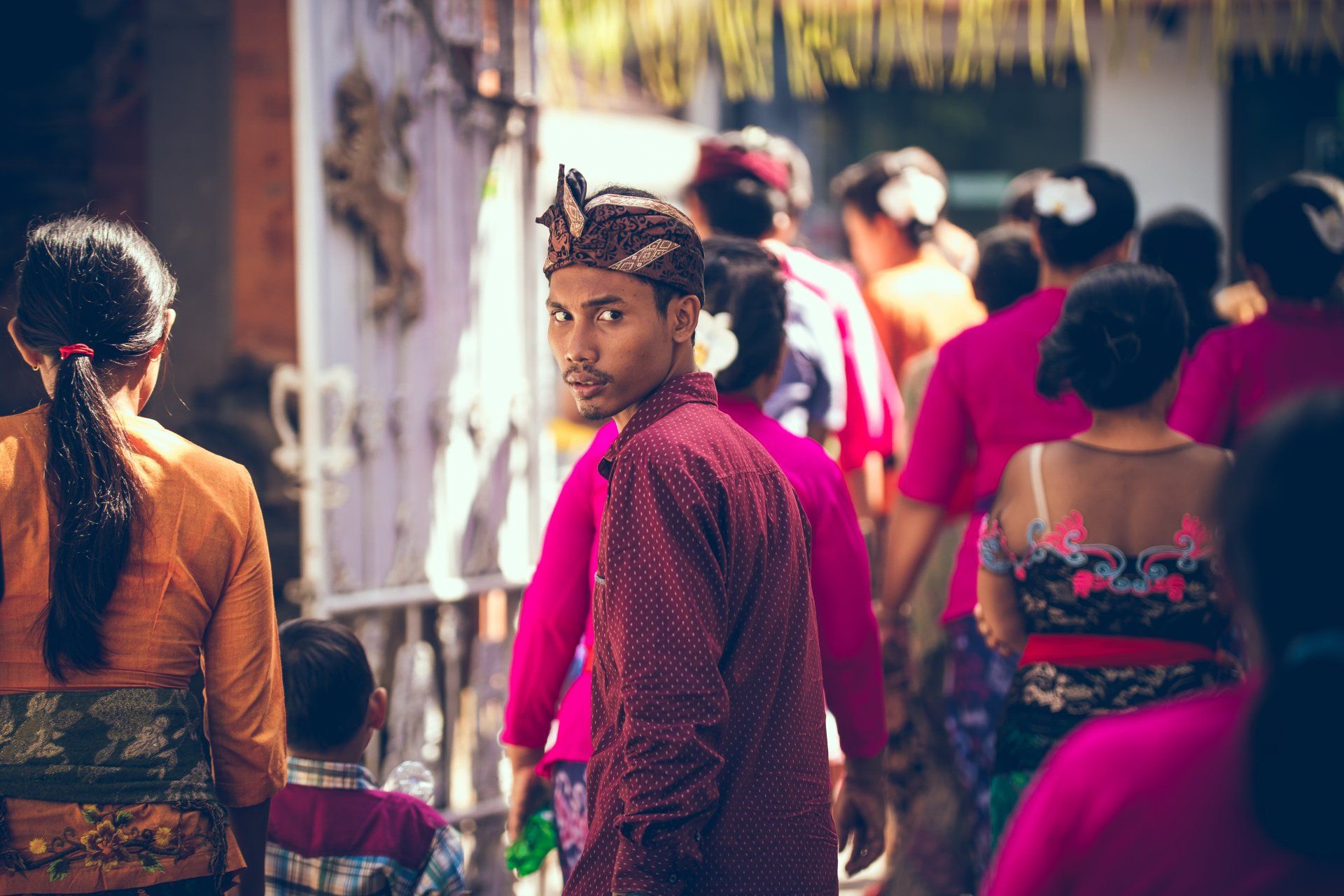 A man in a red shirt is standing in a crowd of people.