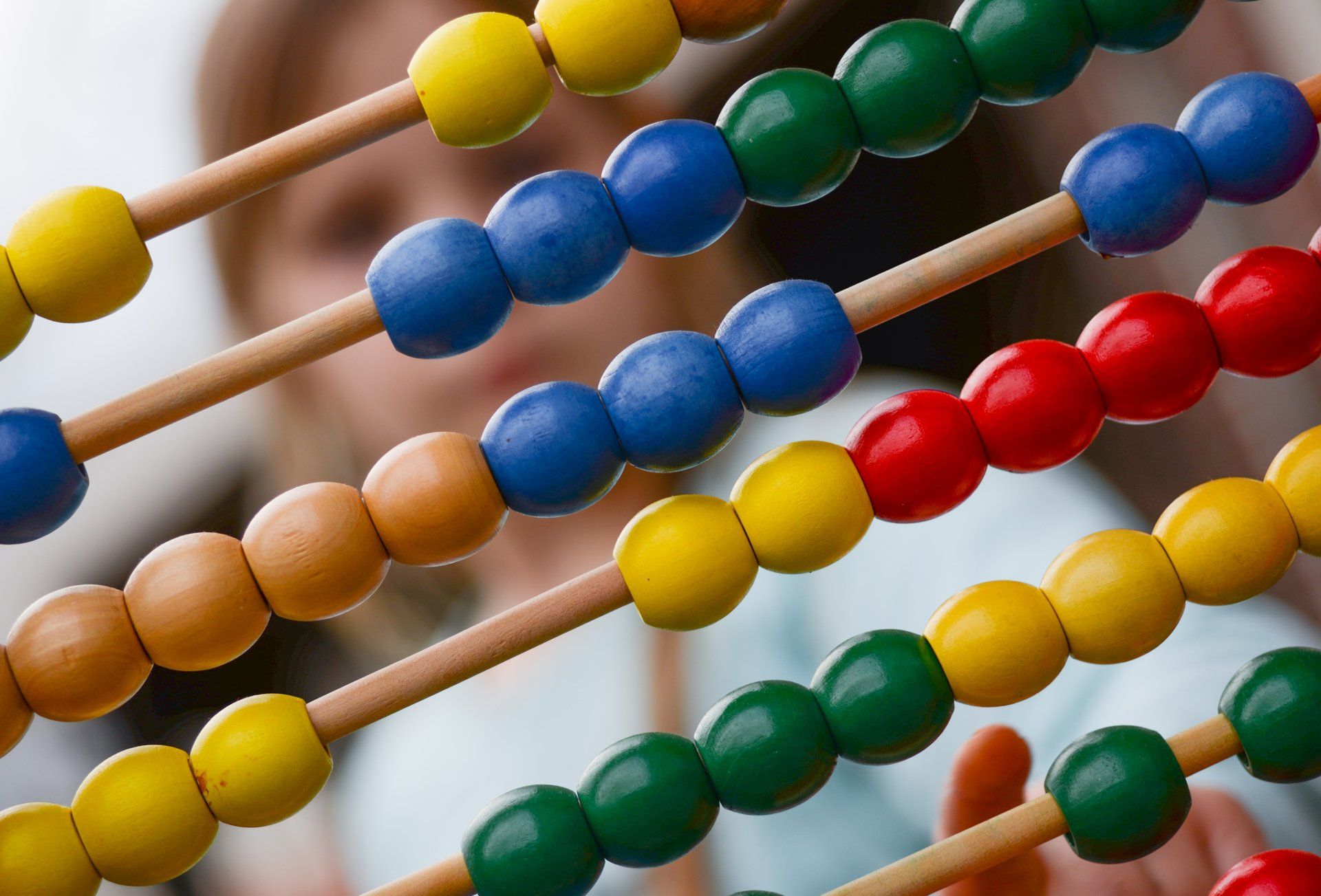 A person is holding a colorful abacus in their hand