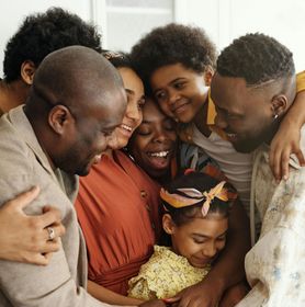 A man is sitting on a couch holding two children.