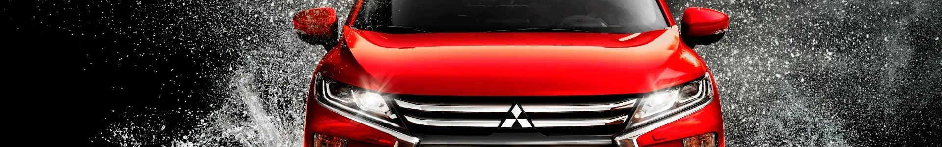 SUV Mitsubishi vermelha atravessando a água.