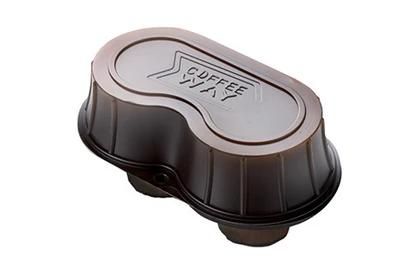 Tappo di plastica nera per capsula di caffè con parte superiore argentata, inclinato su sfondo bianco.