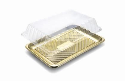 Coperchio a conchiglia in plastica trasparente su un vassoio per alimenti in alluminio dorato.