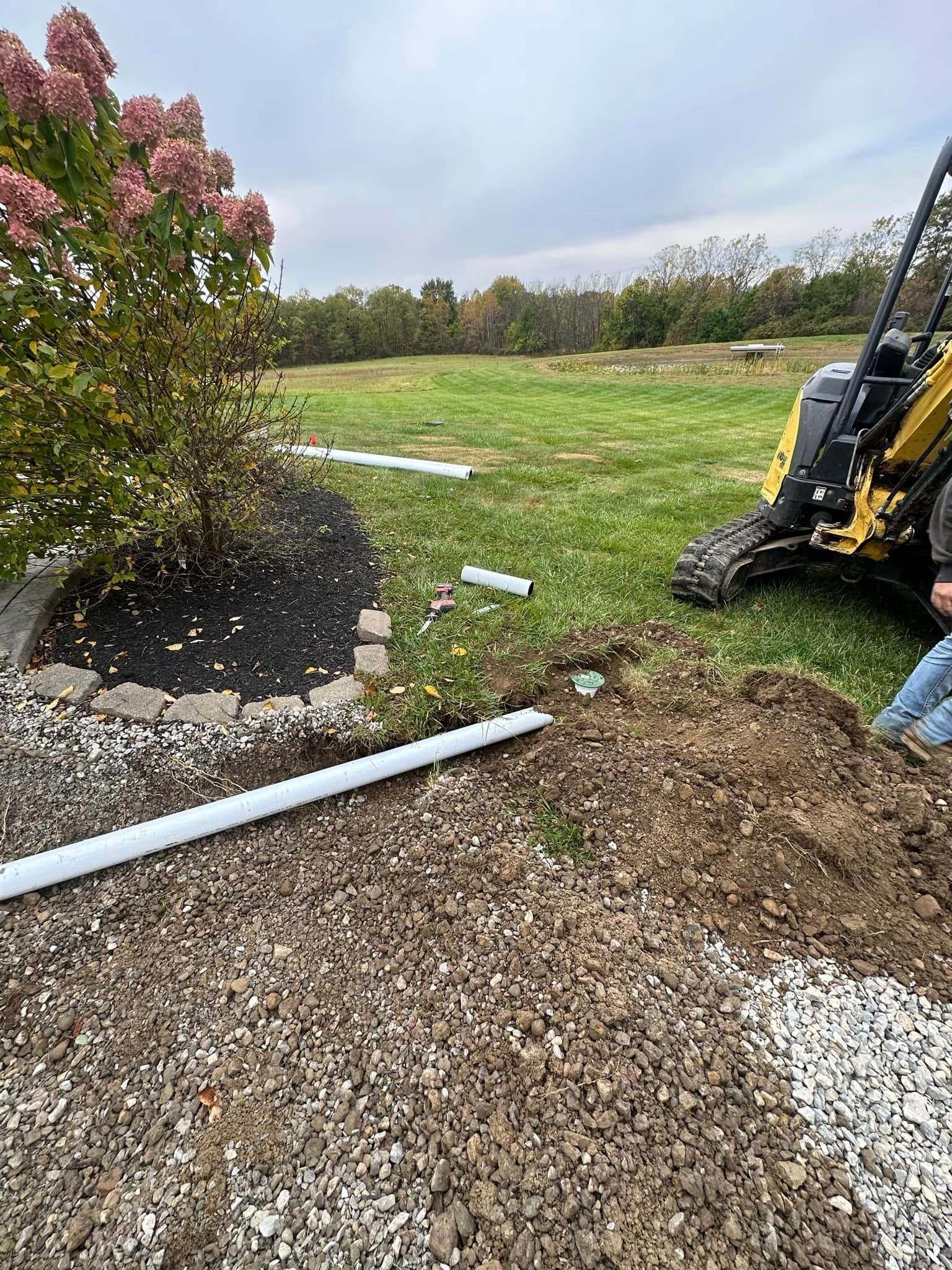 A man is sitting in the dirt next to a tractor.