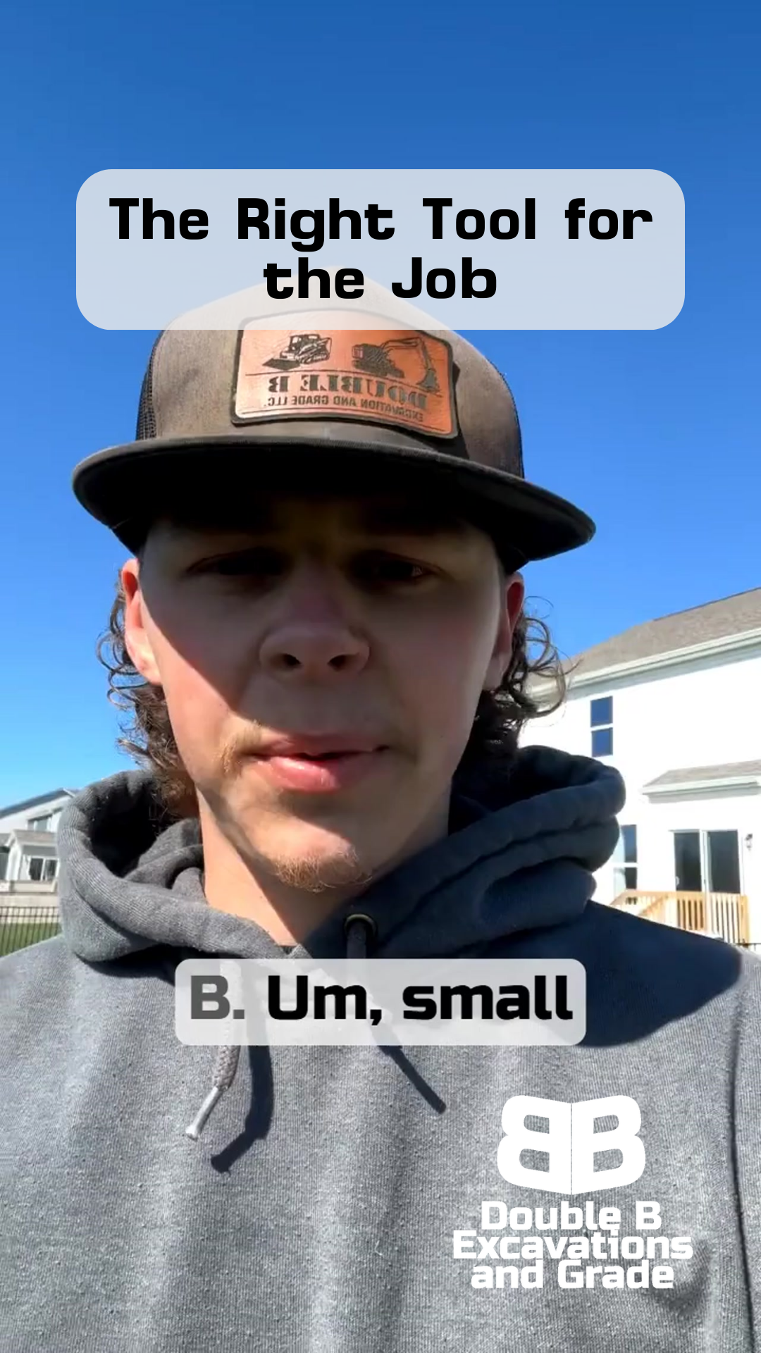 A man wearing a hat and a hoodie is standing in a field.