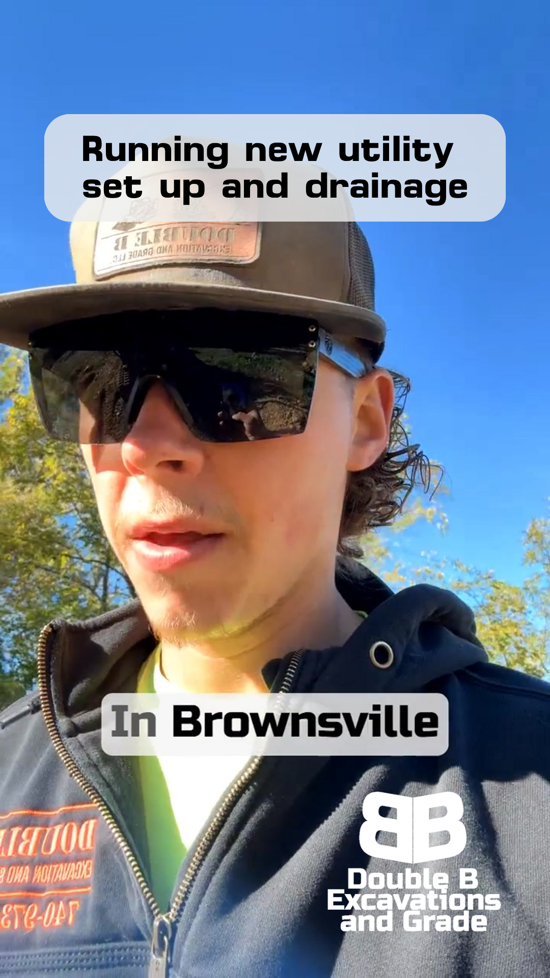 Man in sunglasses, baseball cap, and hoodie, working on utility setup and drainage in Brownsville.