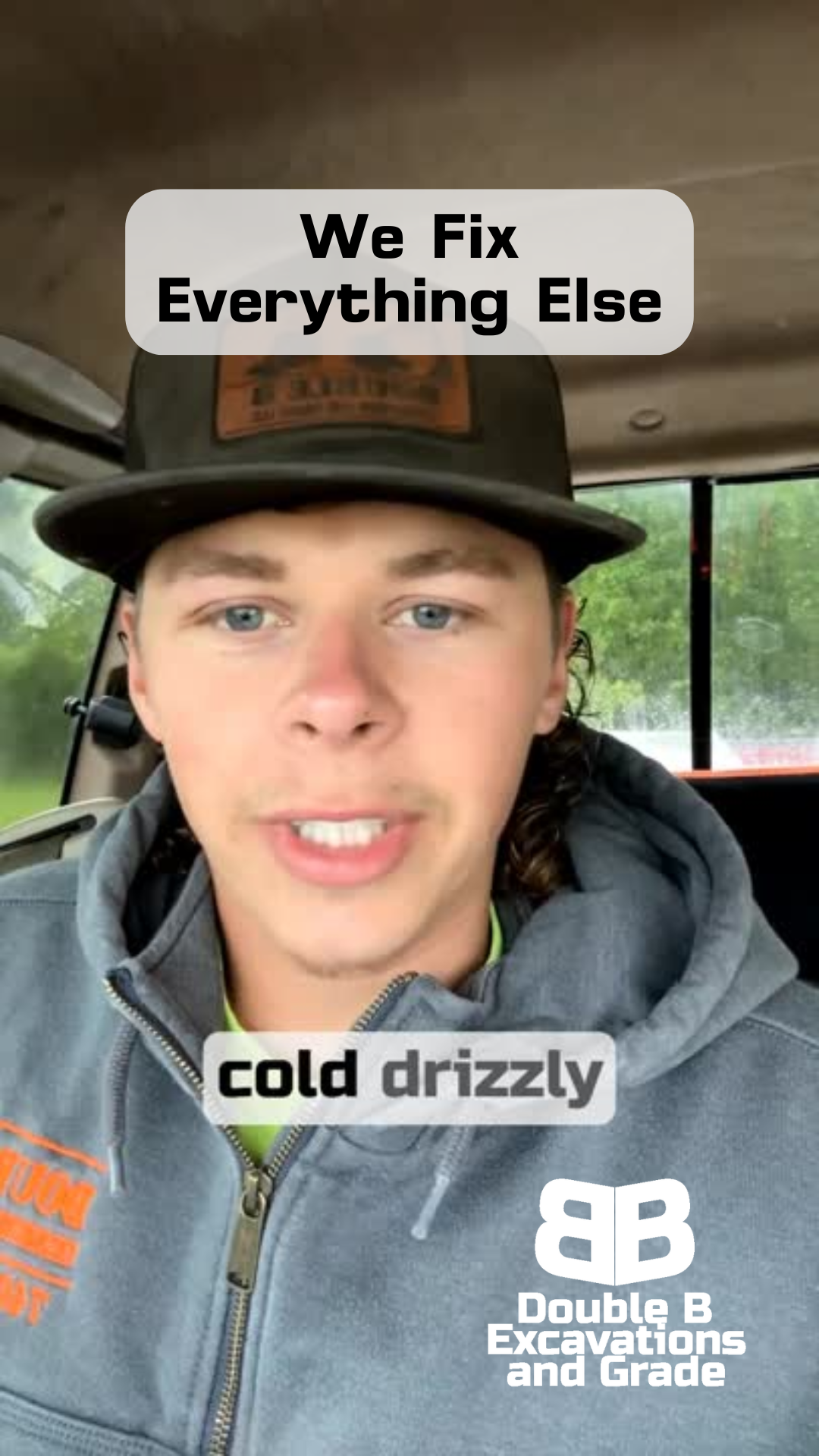 A man wearing a hat and a hoodie is sitting in a car.