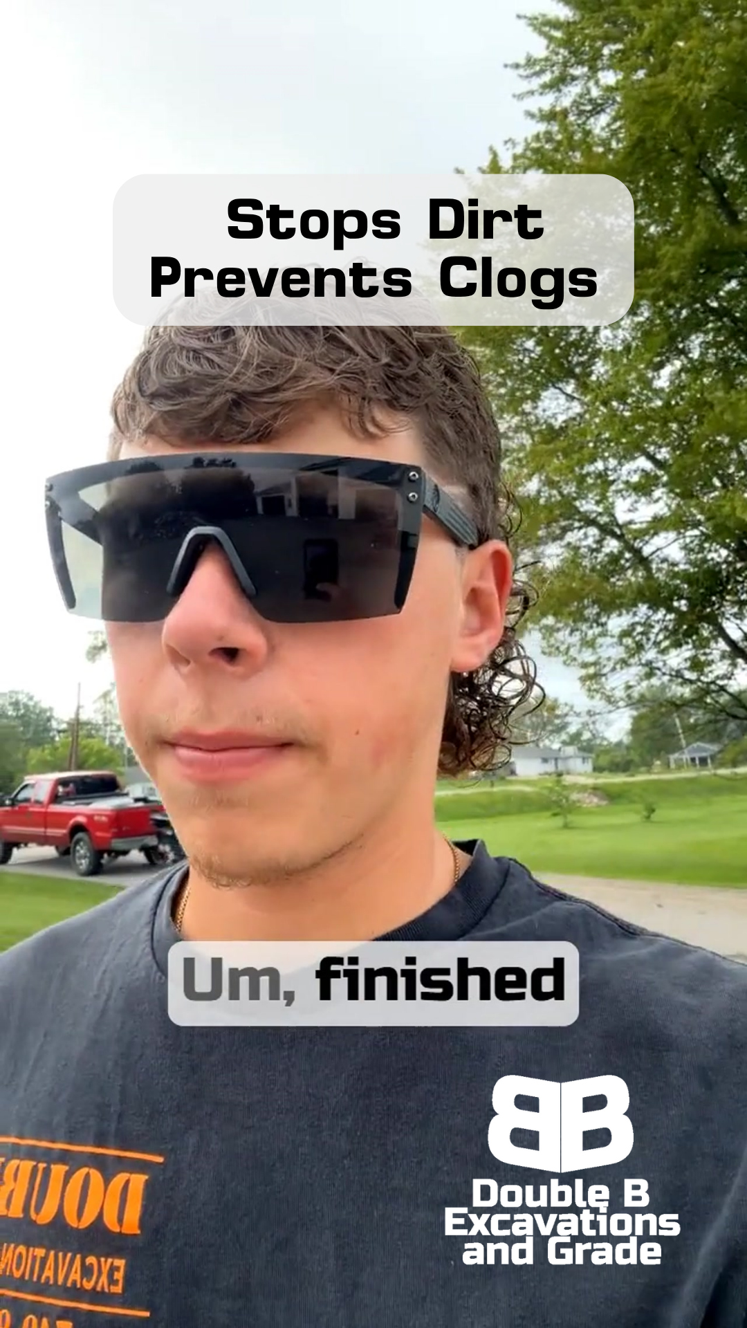 A man wearing sunglasses and a black shirt is standing in a parking lot.
