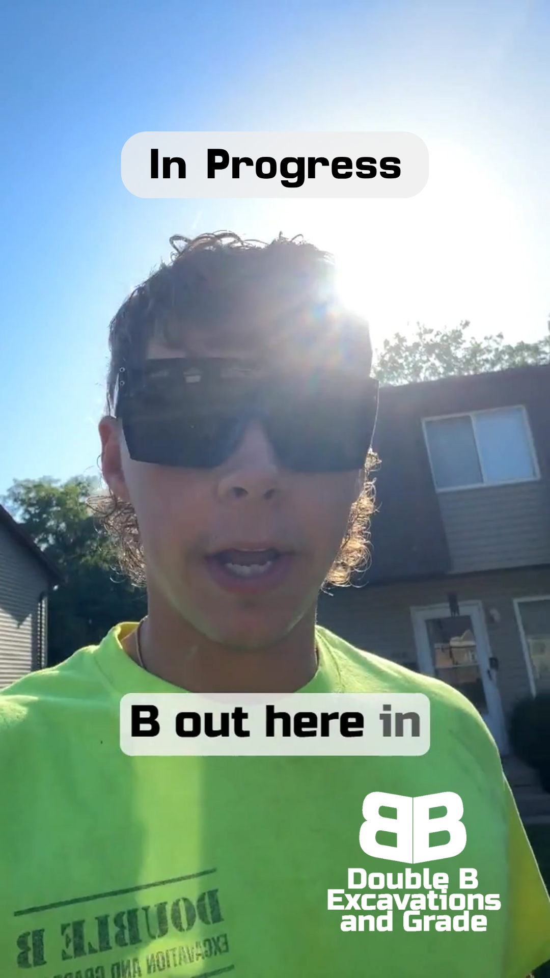 A man wearing sunglasses and a yellow shirt that says double b excavations and grade