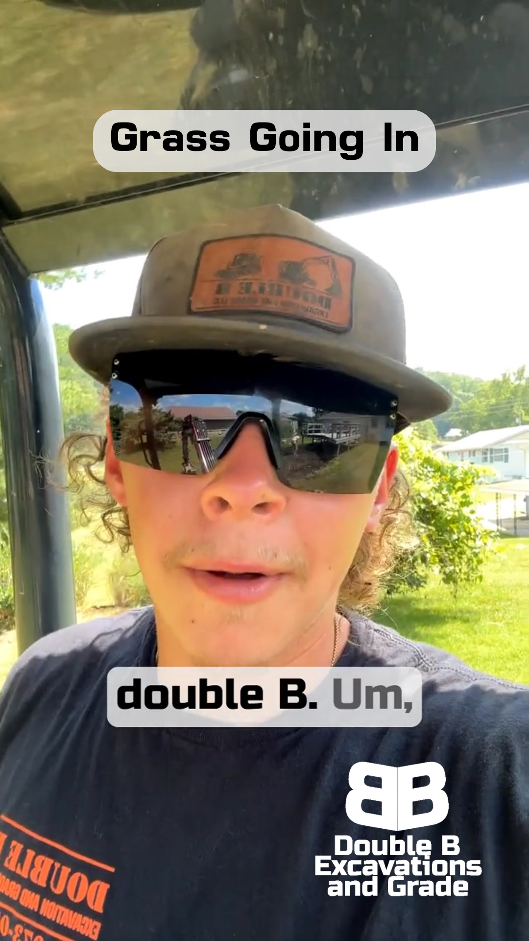 A man wearing sunglasses and a hat is standing in a golf cart.