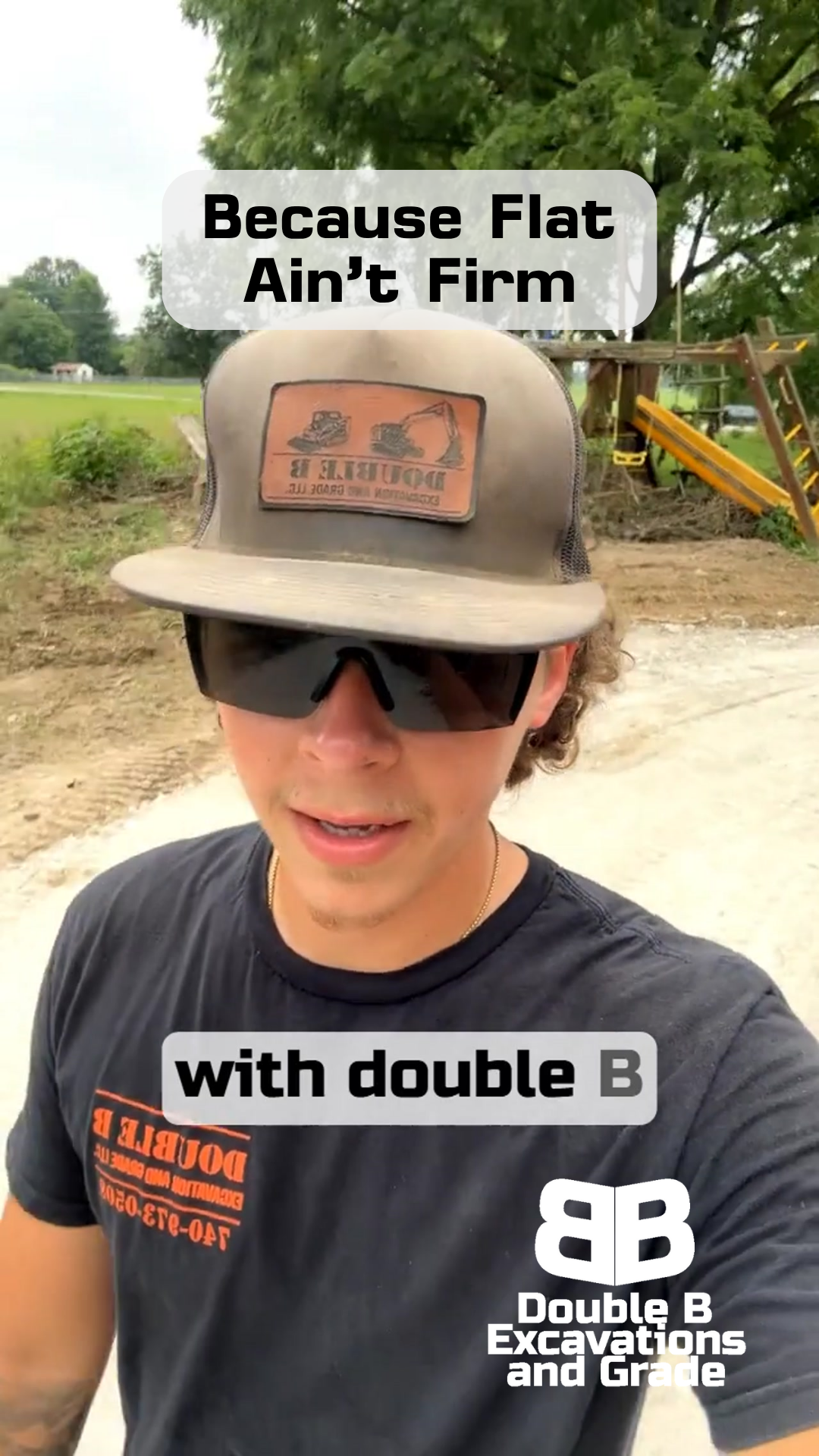 A man wearing a hat and sunglasses is standing on a dirt road.