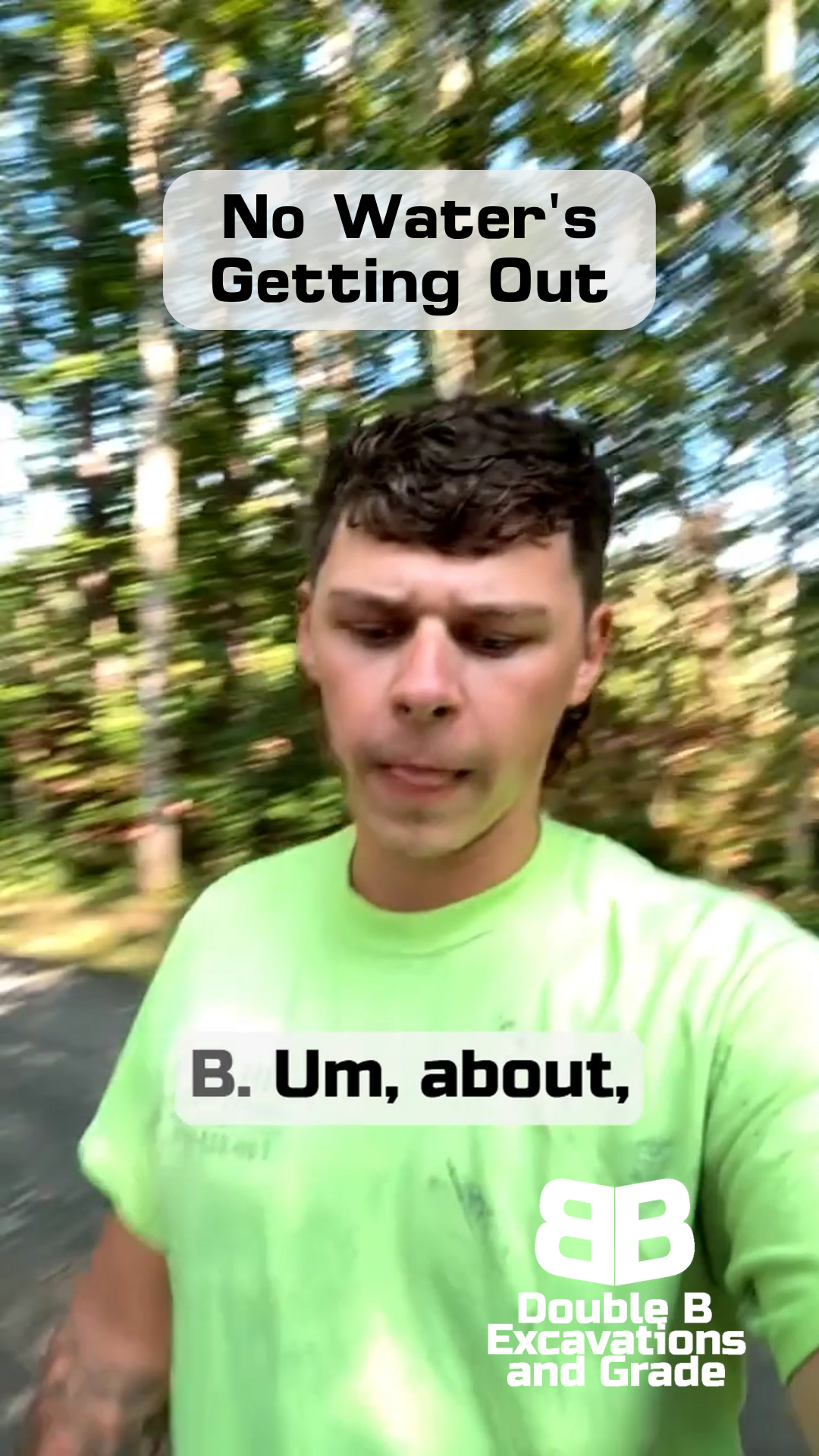 A man in a green shirt is standing on the side of a road.