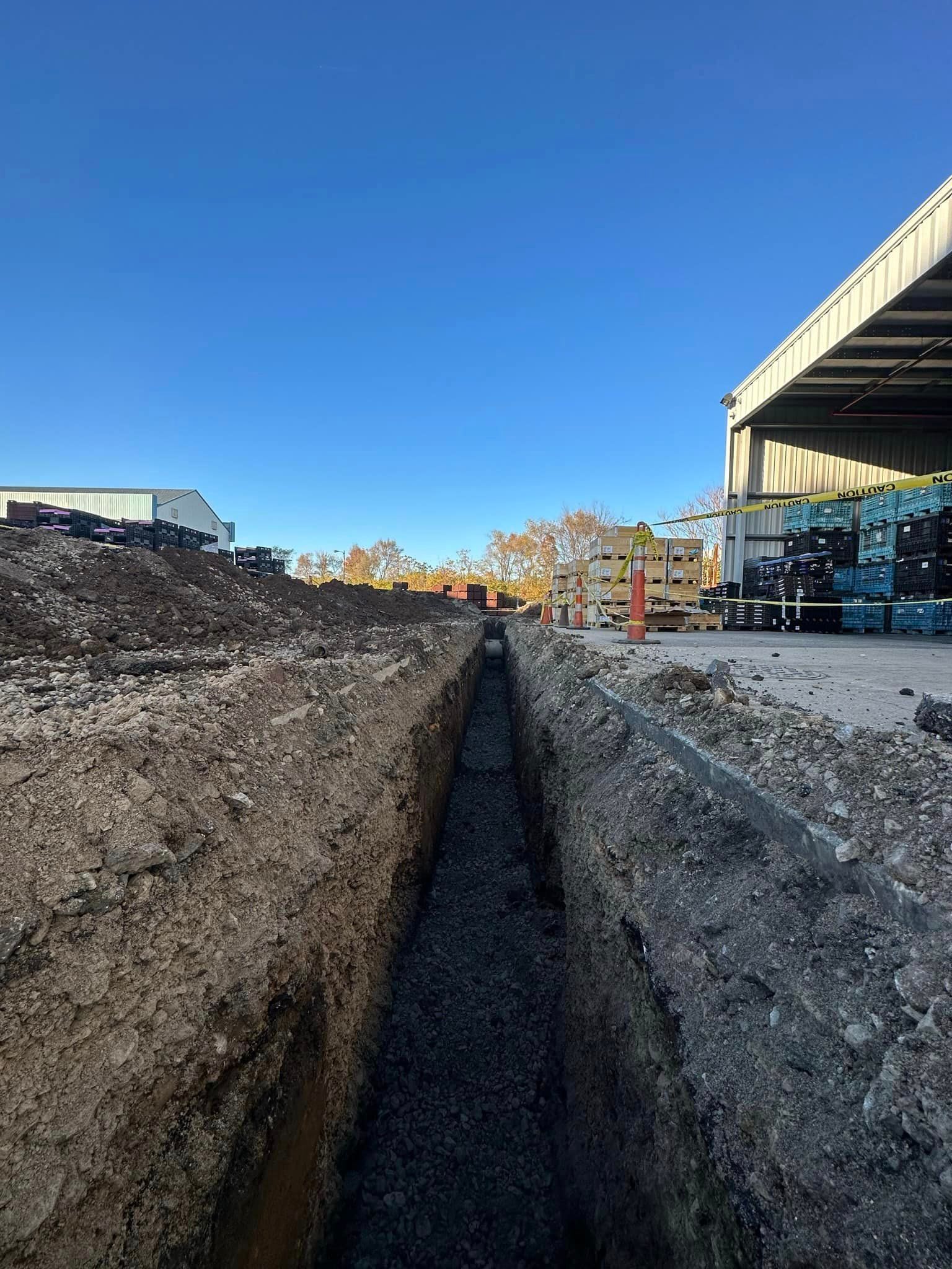 A construction site with a lot of dirt and a building in the background.