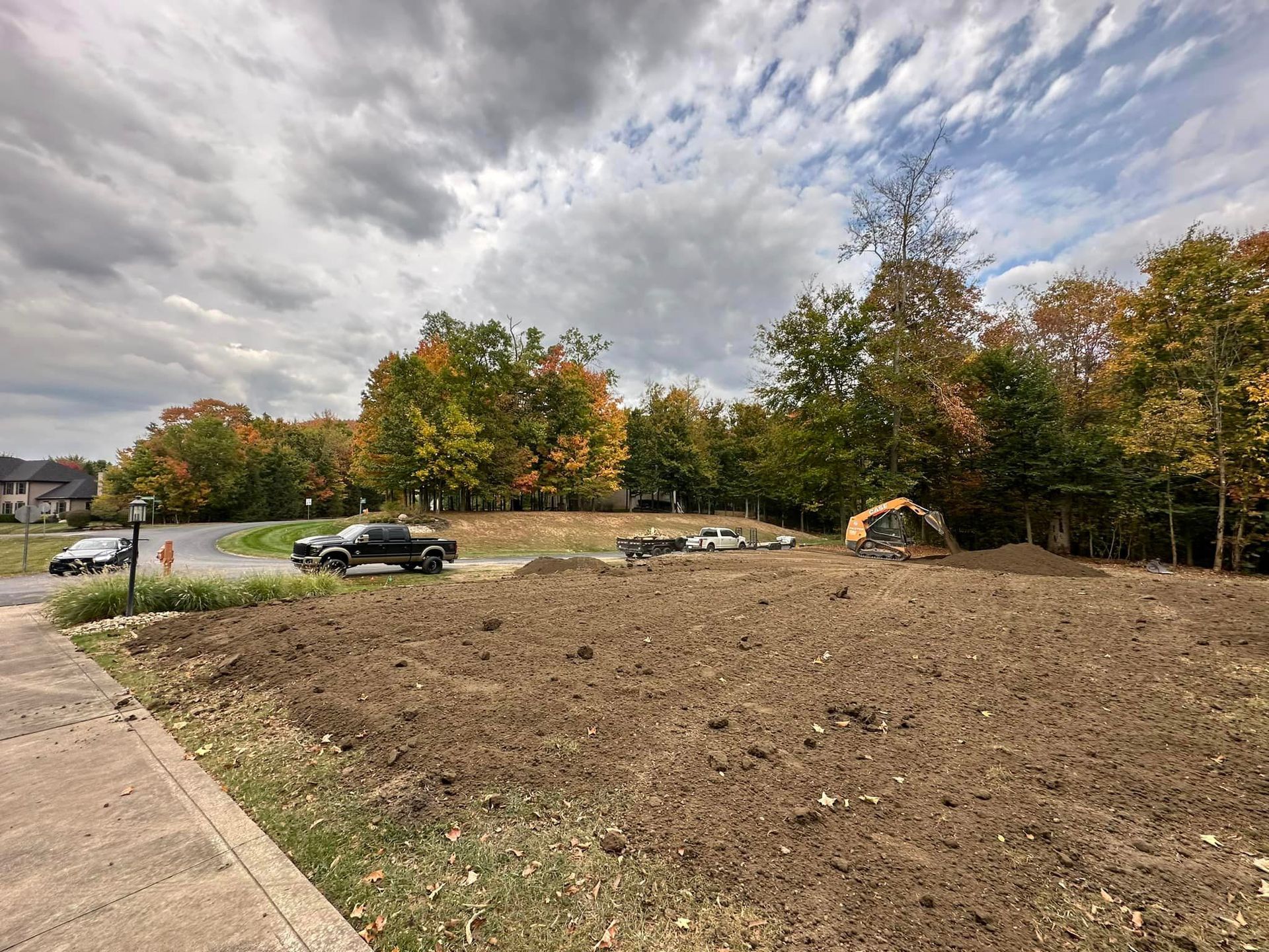 A large dirt field with a lot of trees in the background.