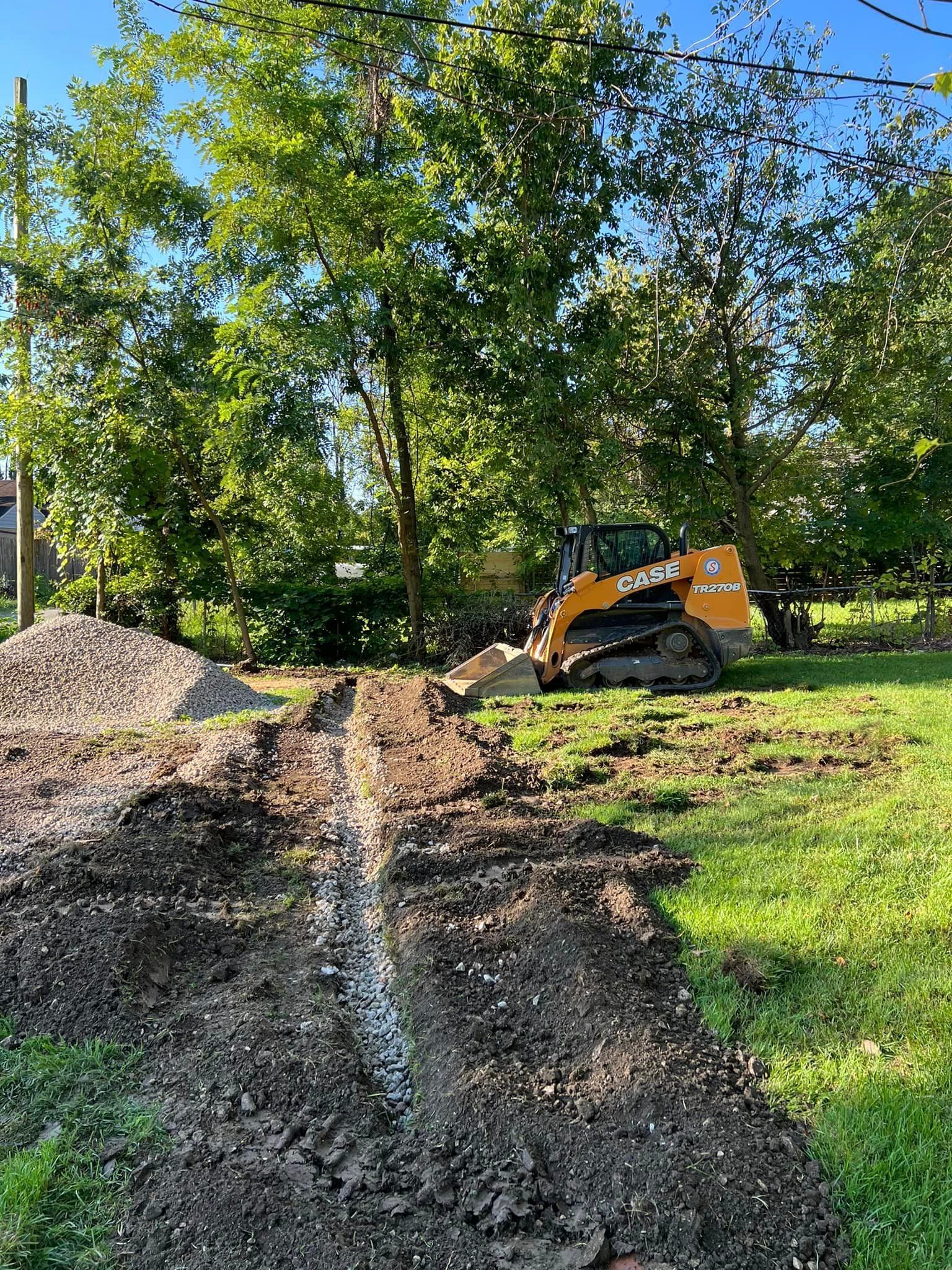 A bulldozer is digging a hole in the dirt in a field.