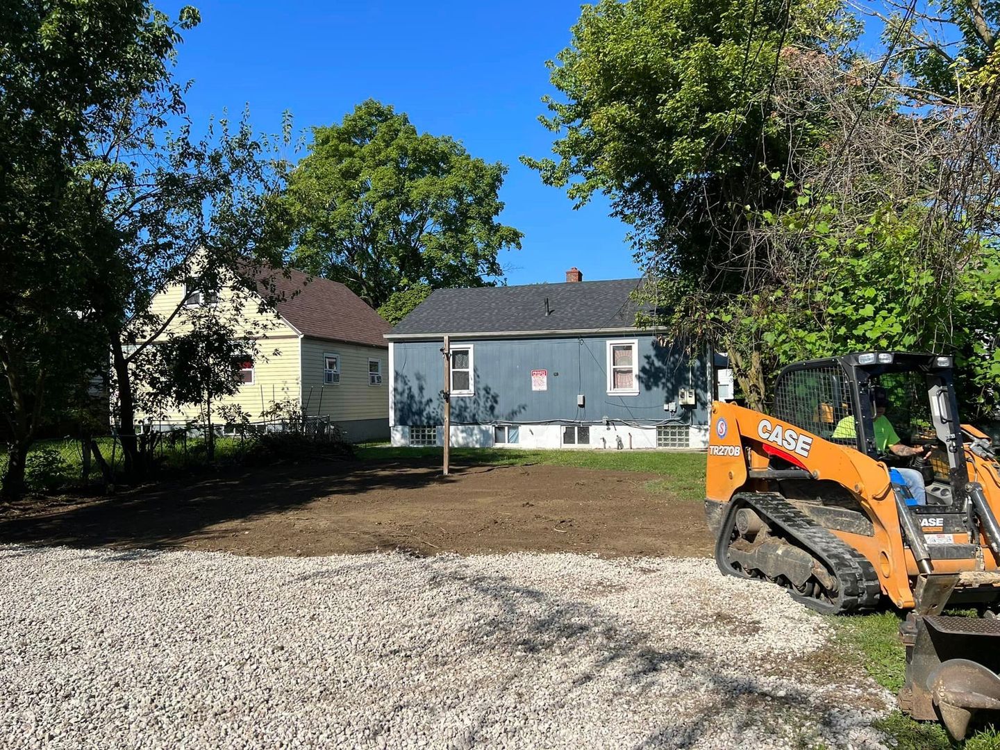 A construction vehicle is parked in front of a house.