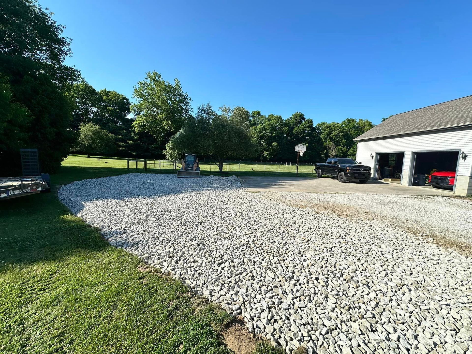 A gravel driveway with a garage in the background