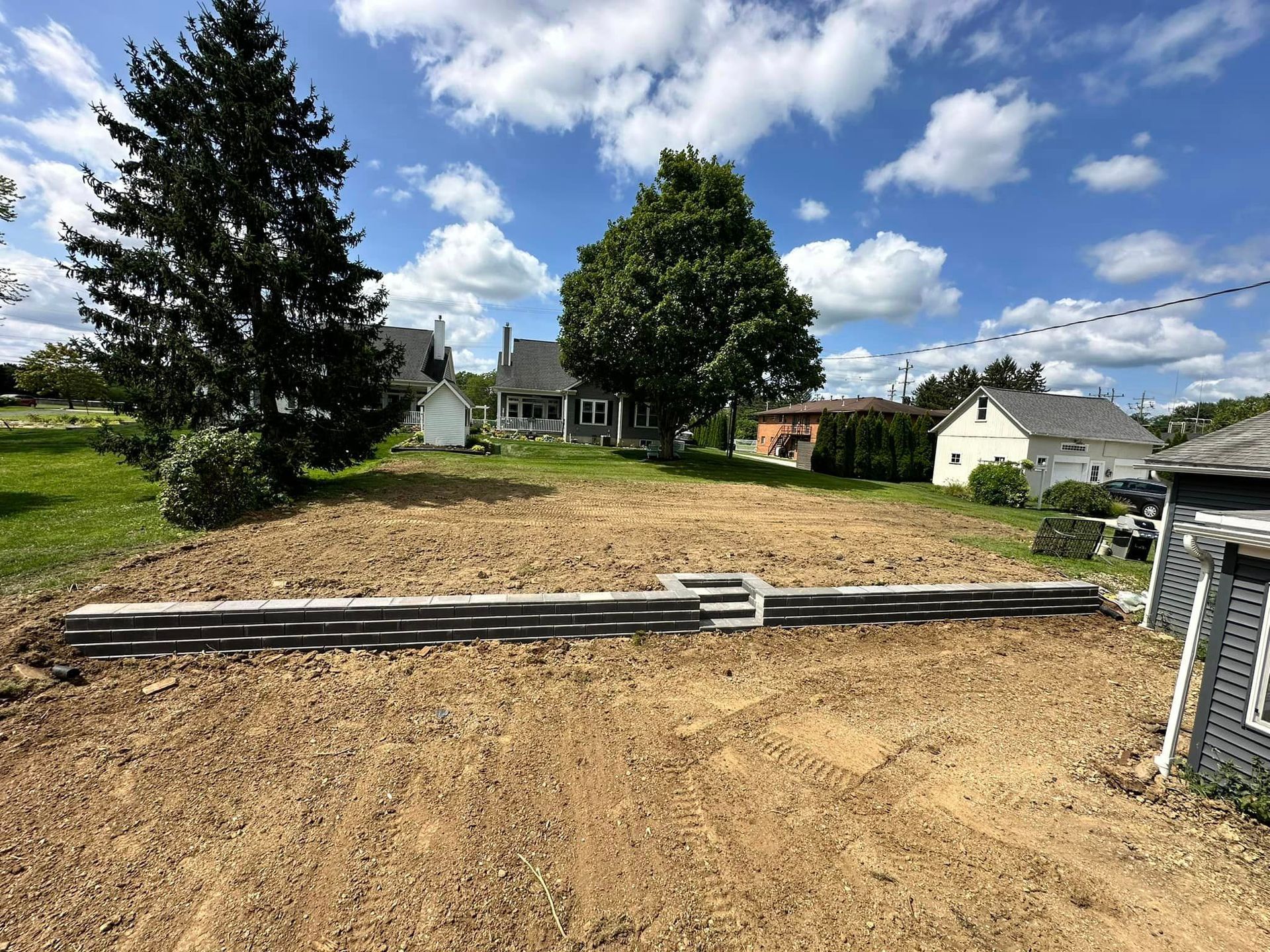 A dirt field with a house in the background.