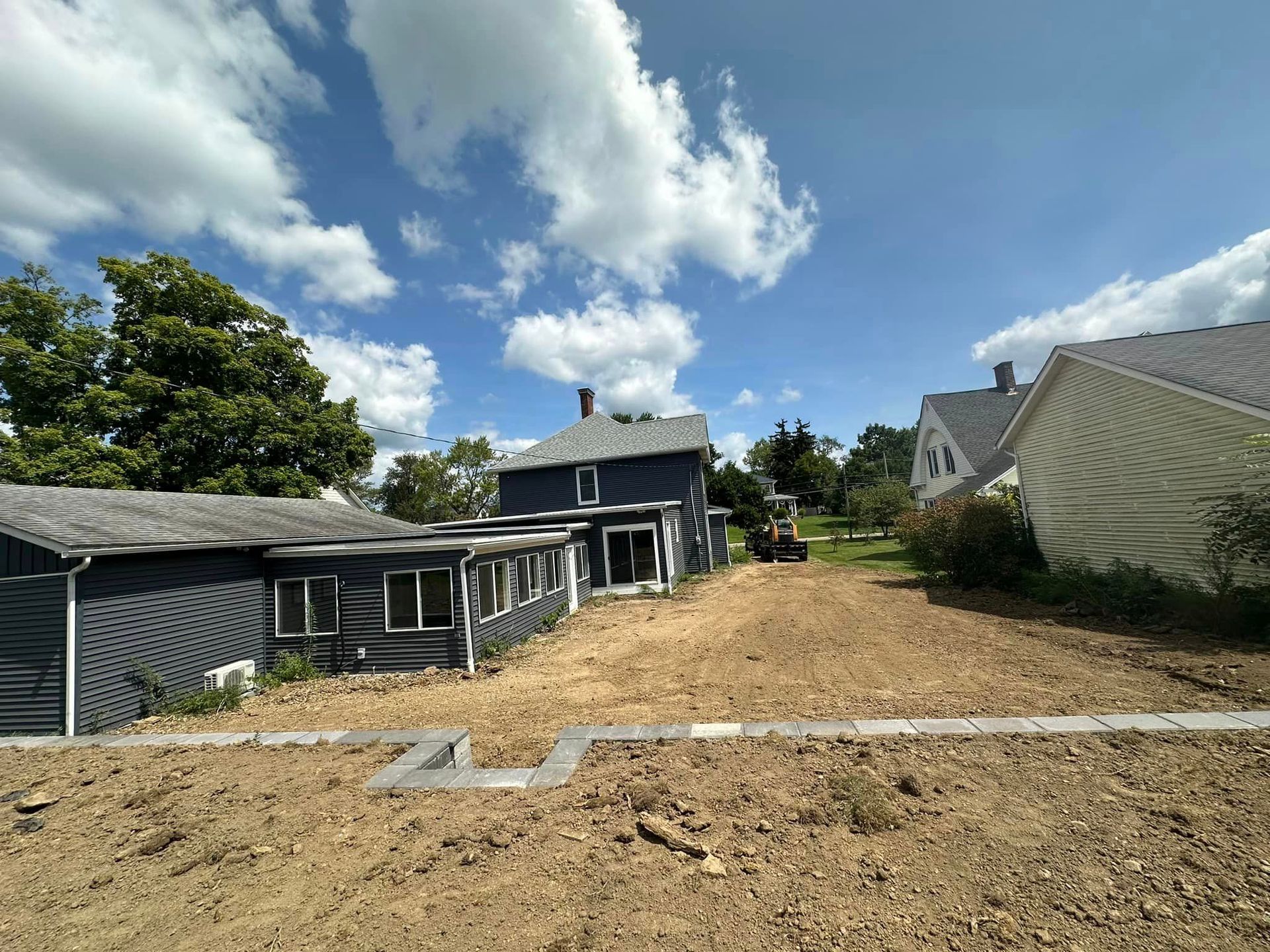 A dirt road leading to two houses on a sunny day.