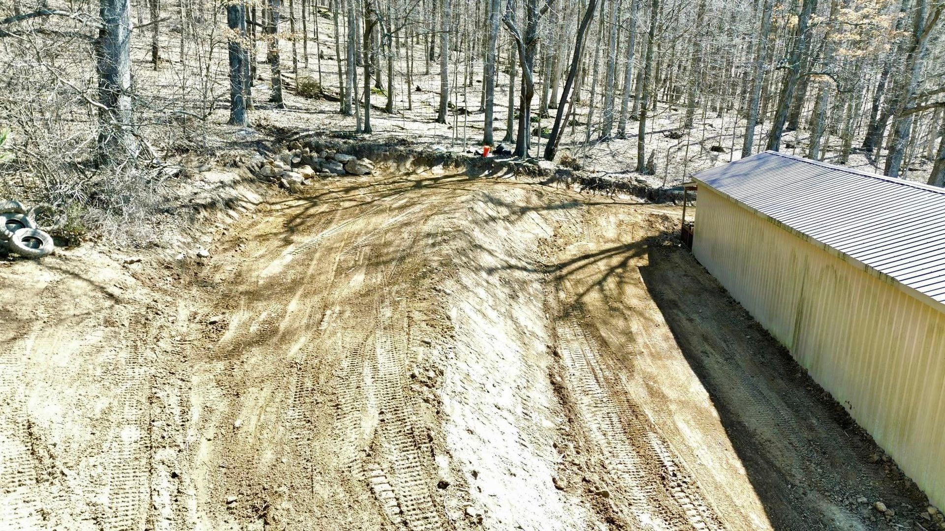 An aerial view of a dirt road in the woods.