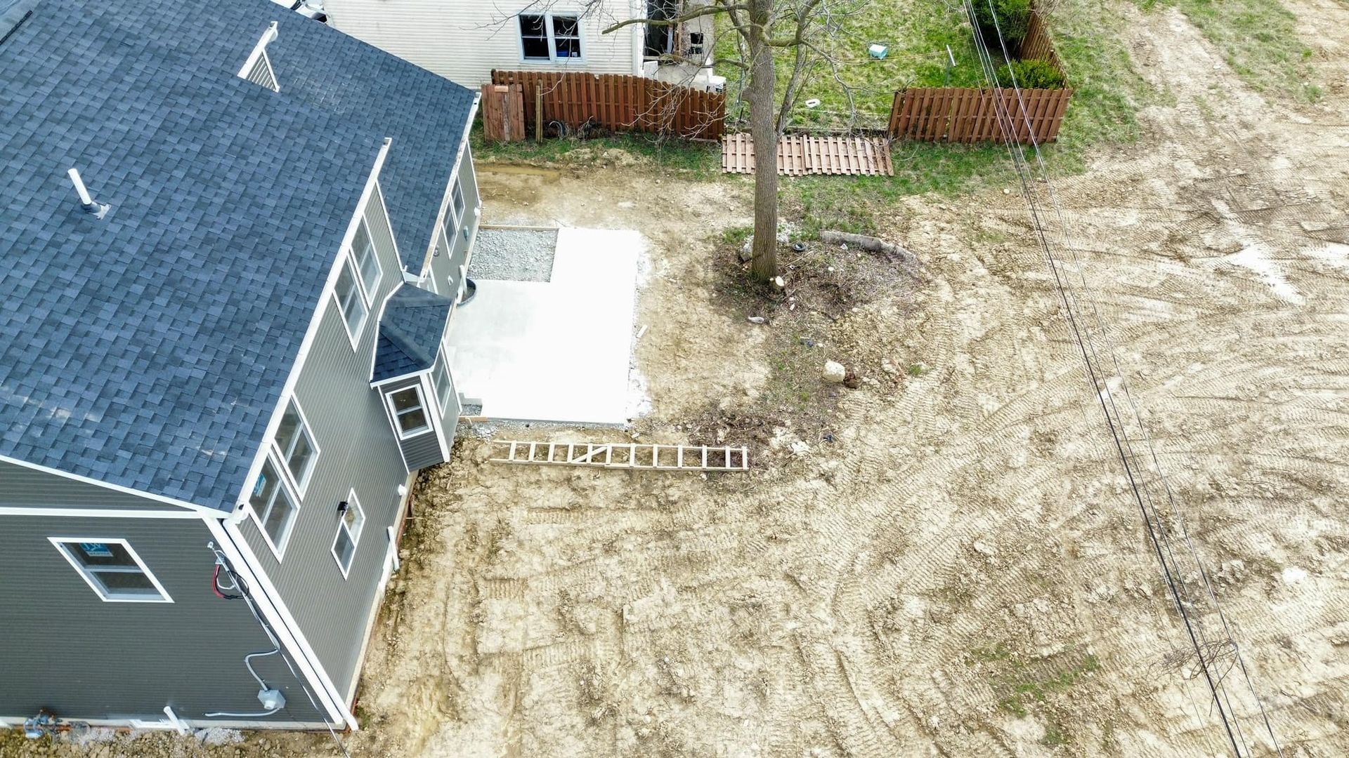 An aerial view of a house sitting on top of a dirt field.