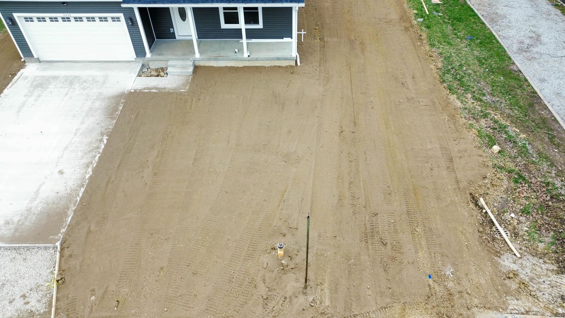 An aerial view of a dirt driveway leading to a house.