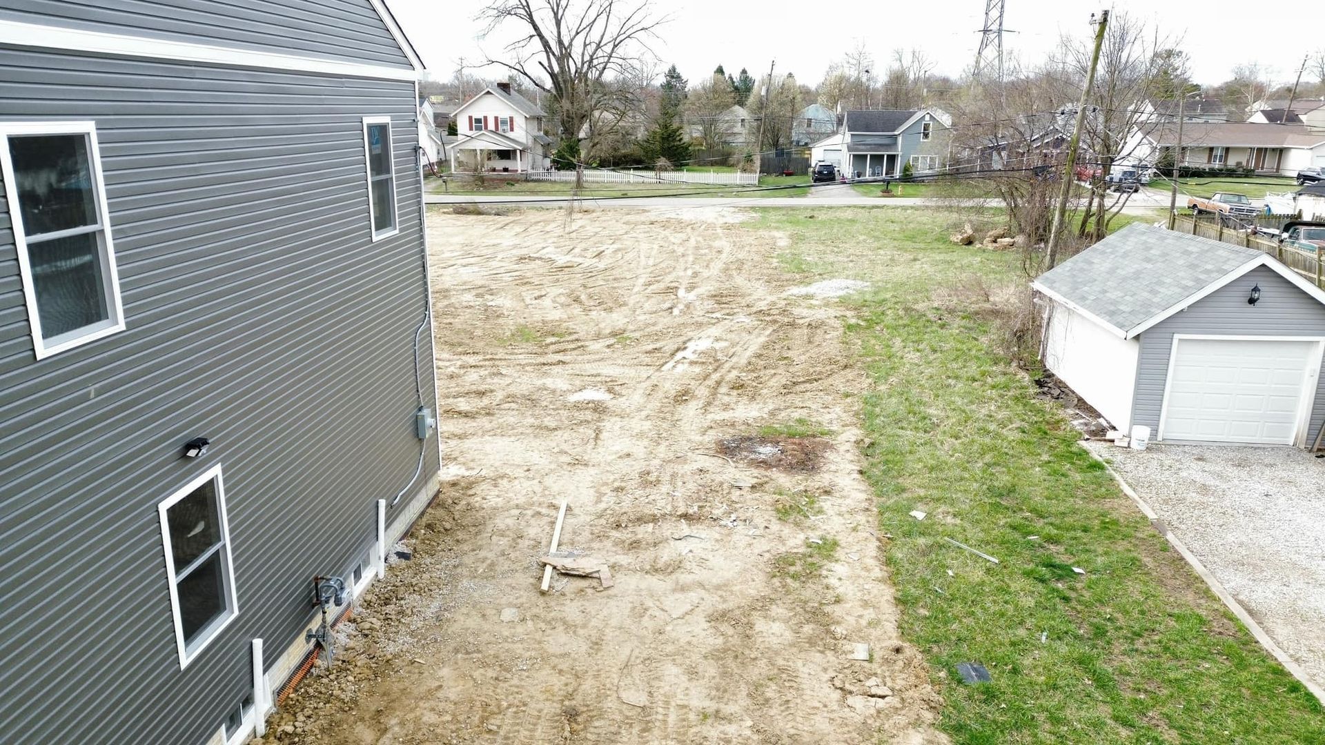 An aerial view of a house and a garage in a residential area.