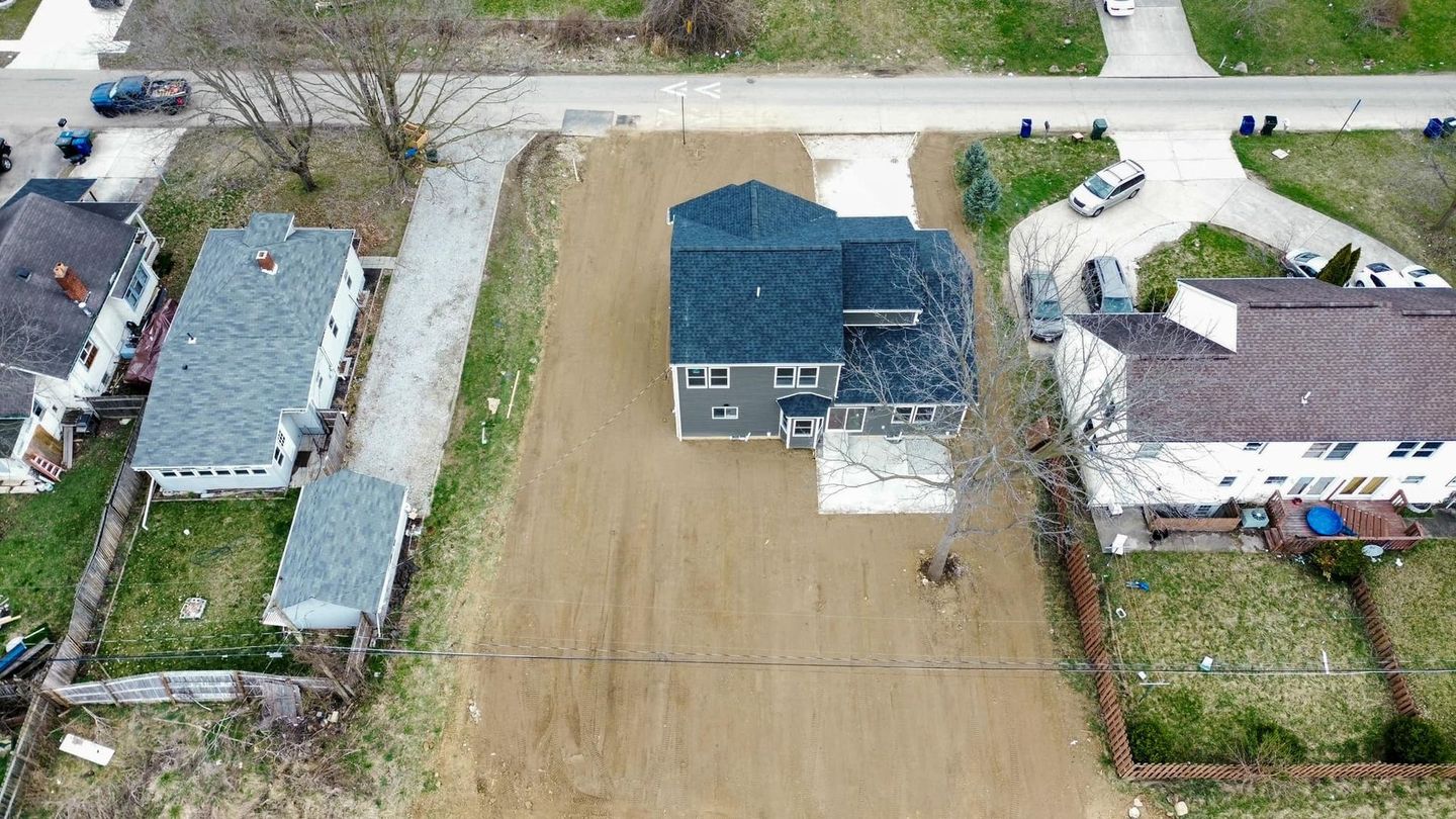 An aerial view of a house and a driveway in a residential area.