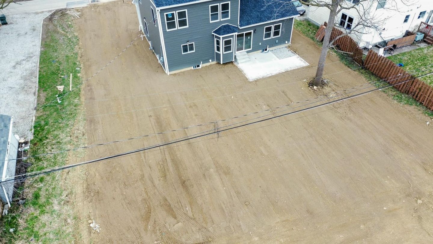 An aerial view of a house with a lot of dirt in front of it.