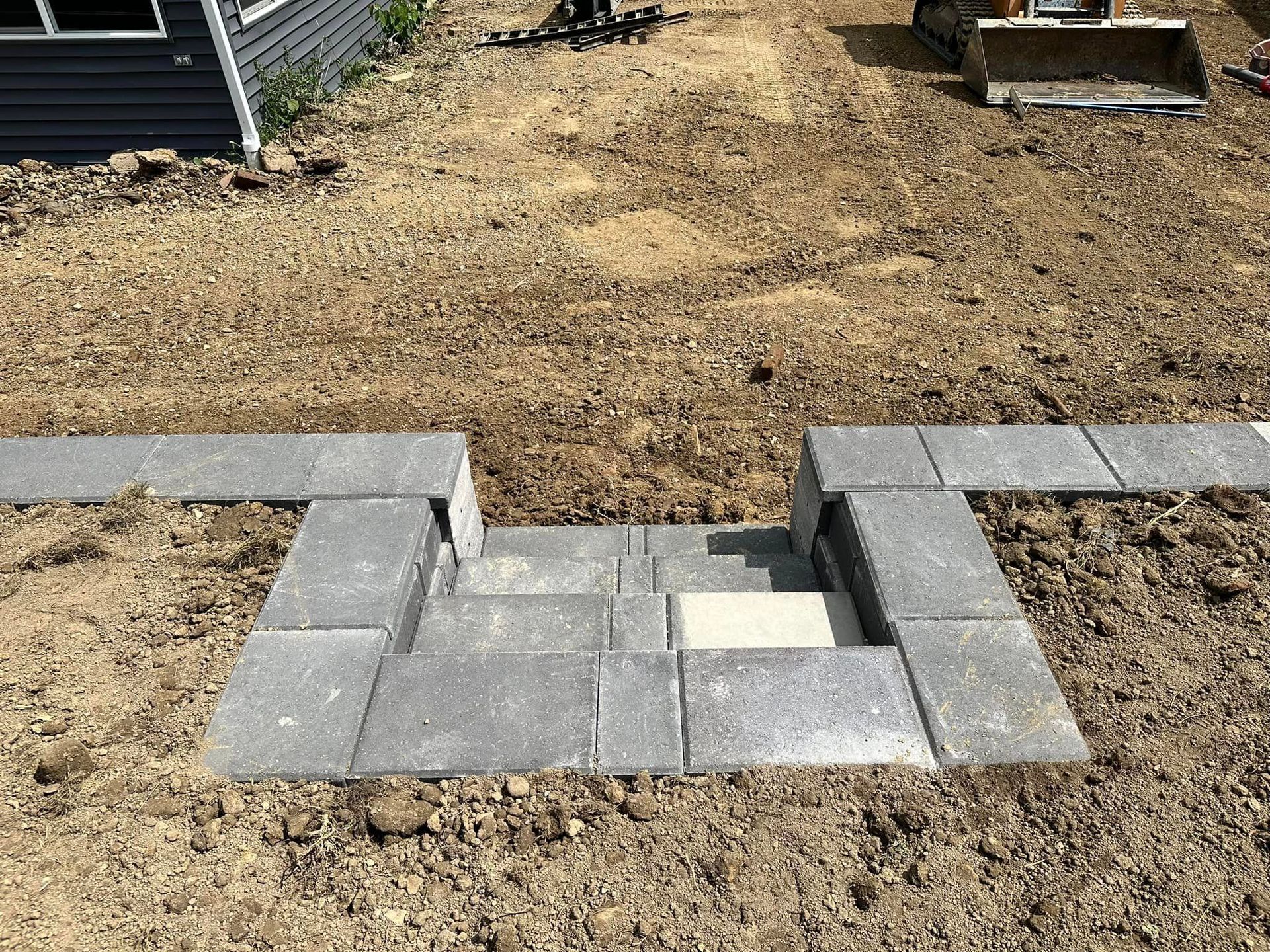 A staircase is being built in the middle of a dirt field.