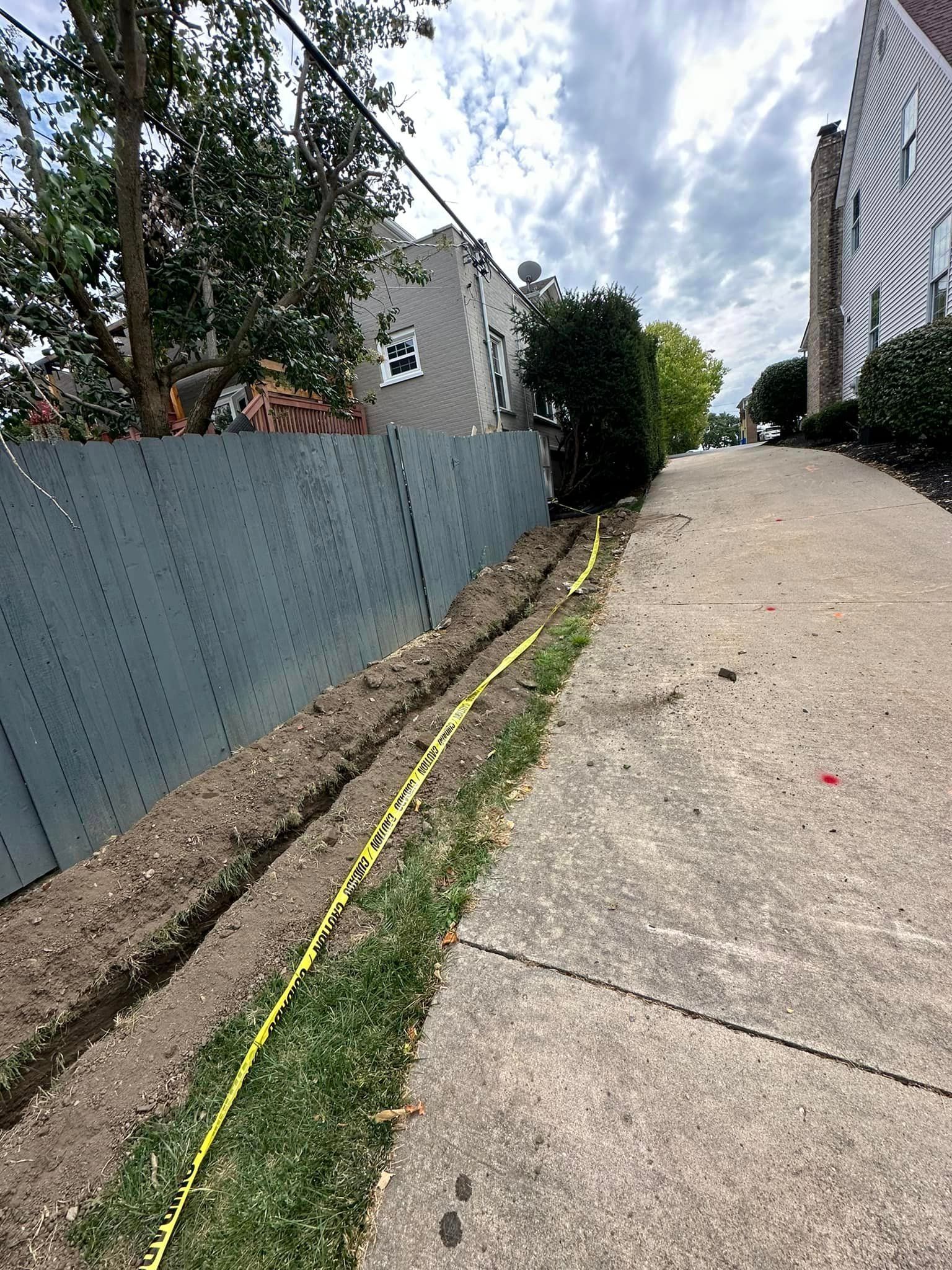 A concrete sidewalk with a yellow tape along the side of it.