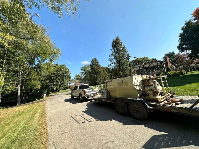 A truck is pulling a trailer with a machine on it.