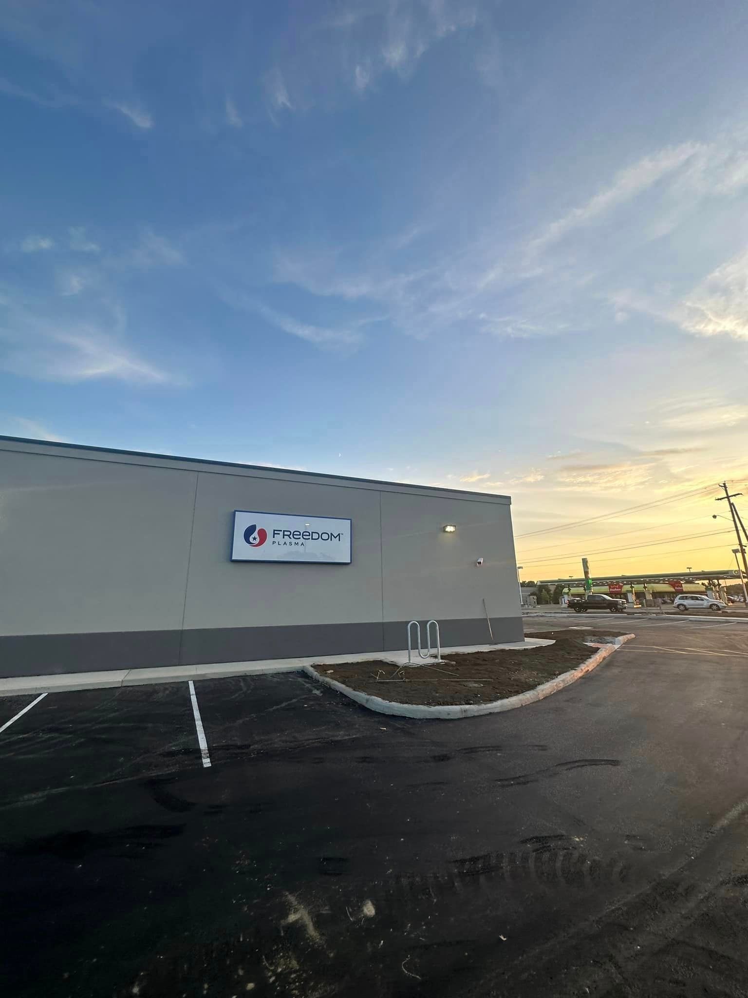 A large building with a sign on the side of it and a parking lot in front of it.