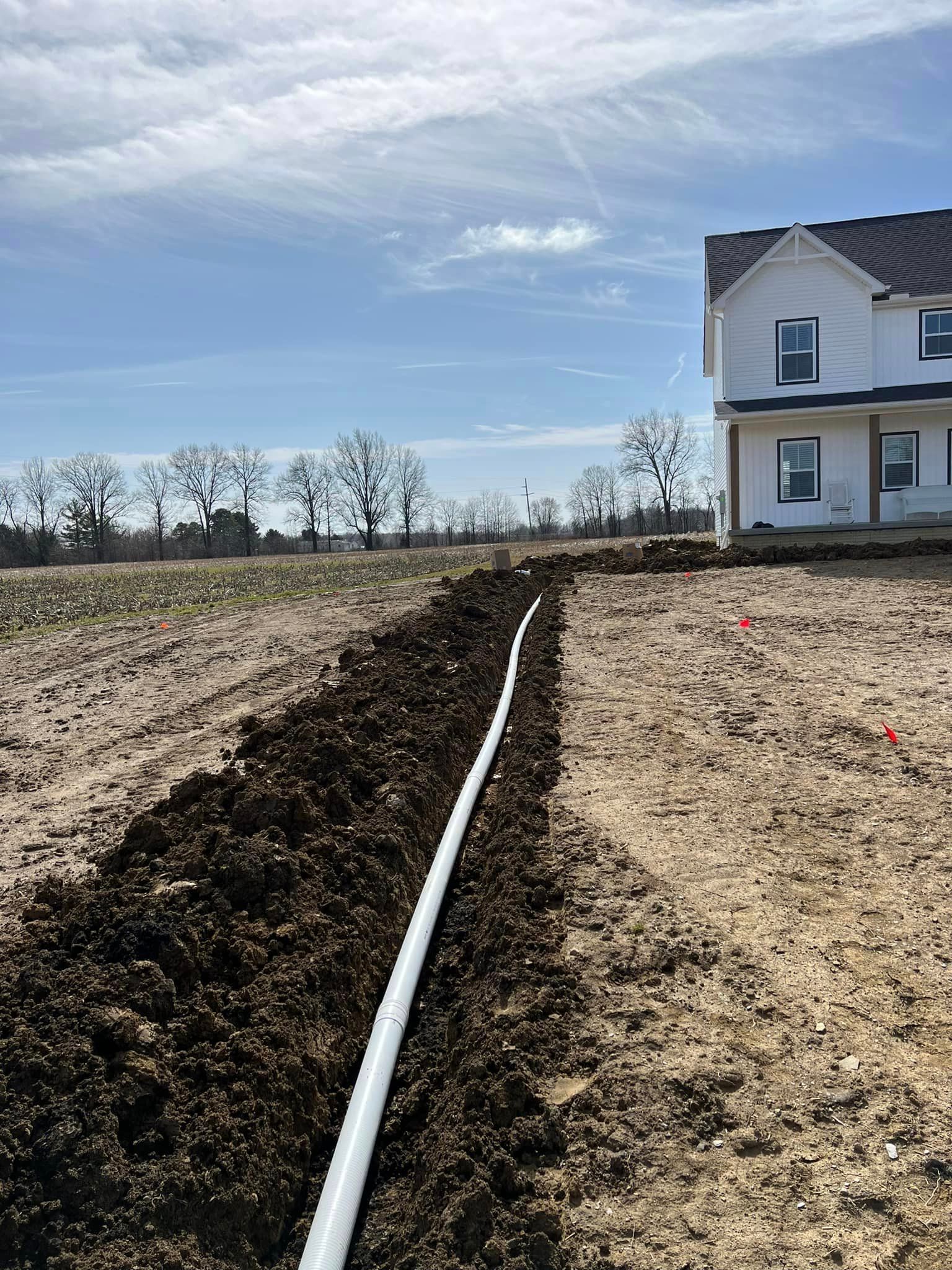 A white house is sitting in the middle of a dirt field.