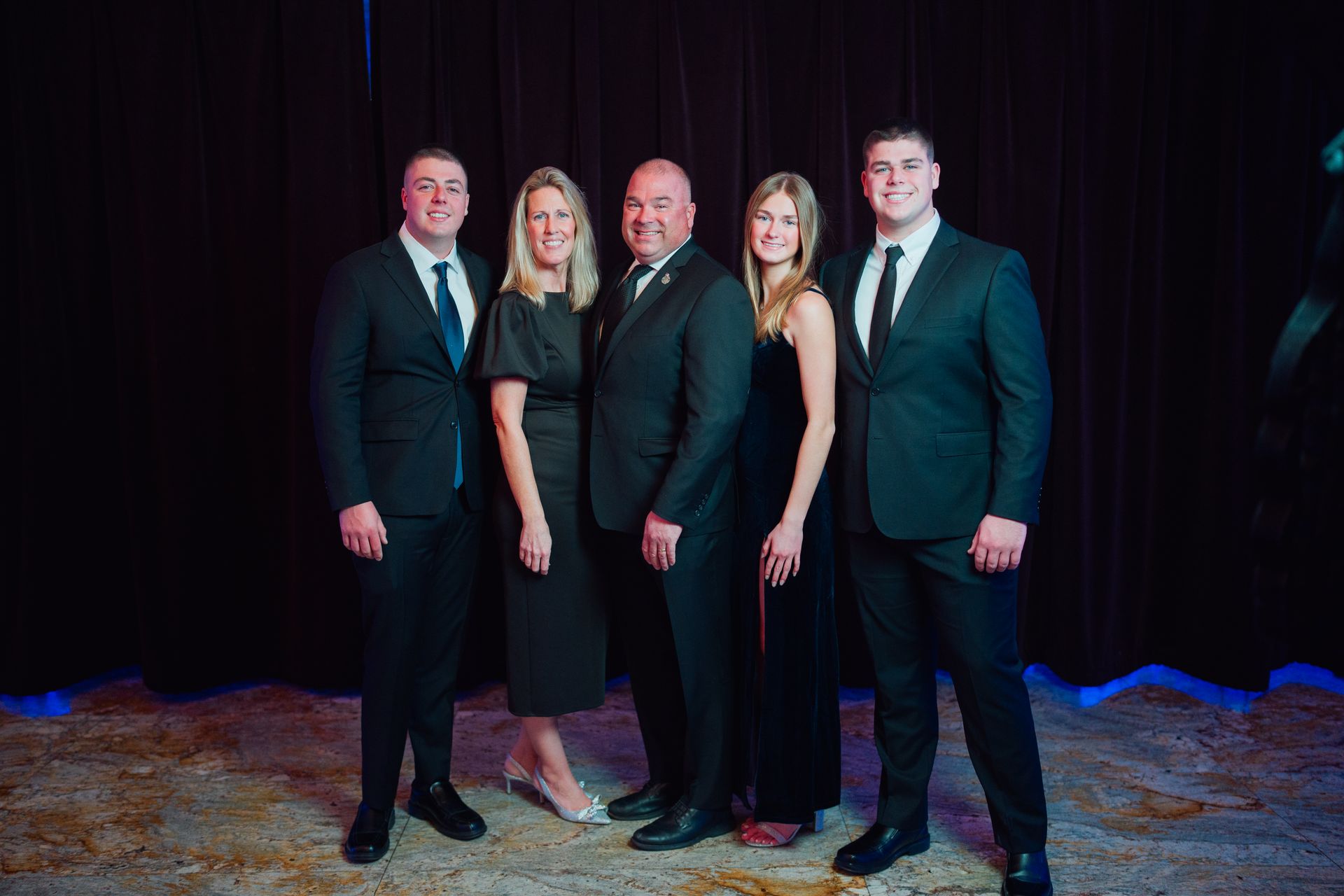 a family posing for a picture in front of a stone wall
