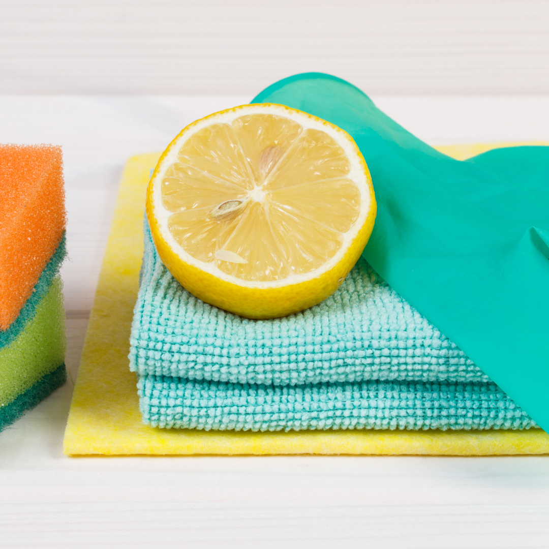 cleaning rags, glove and sponge with sliced lemon