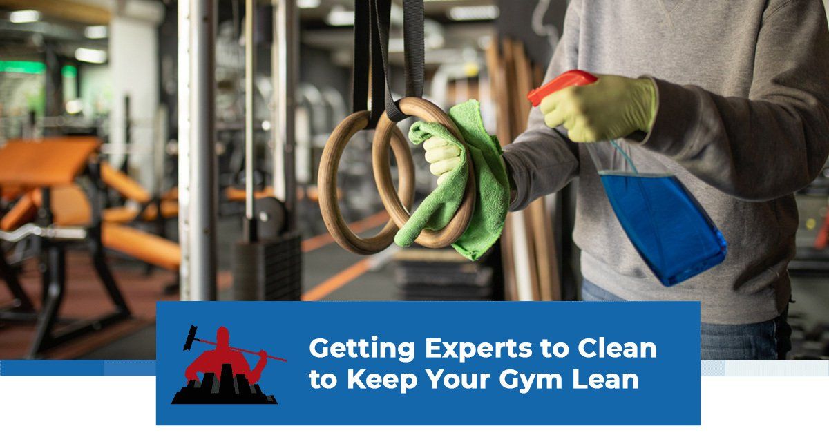 A professional cleaner disinfecting and wiping handles of gym equipment
