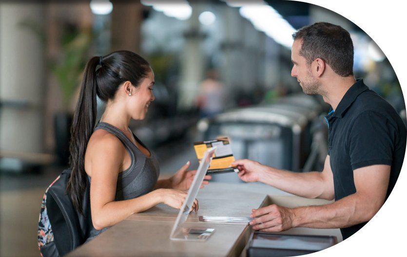 A gym member talking to a staff member at front desk