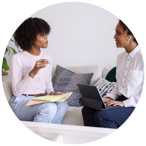 two young business professional black women having interview conversation wearing smart casual outfits