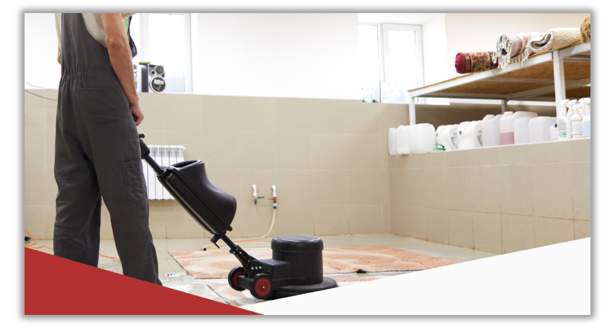 A man is cleaning the floor with a vacuum cleaner.