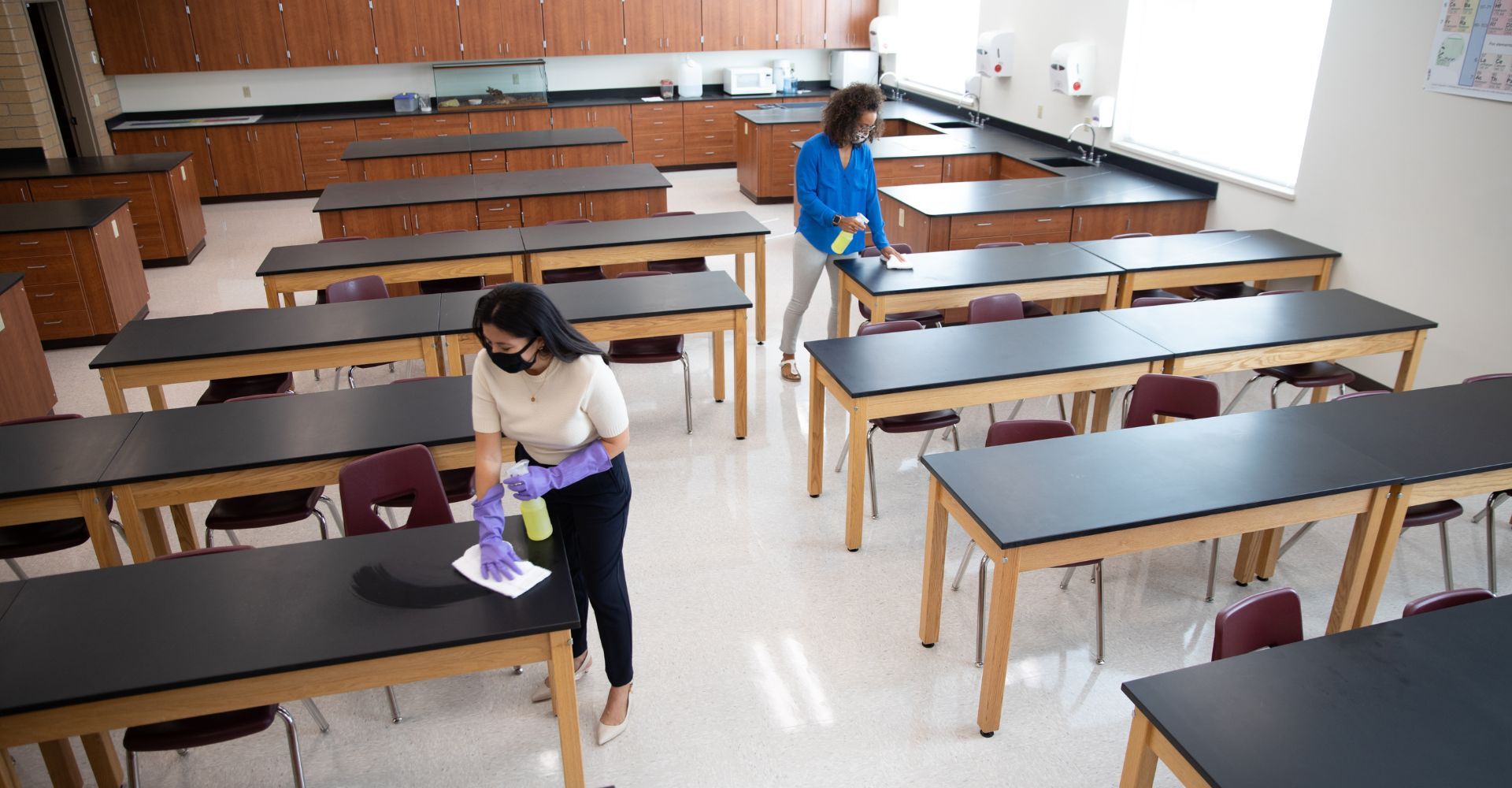 Two teachers cleaning a classroom