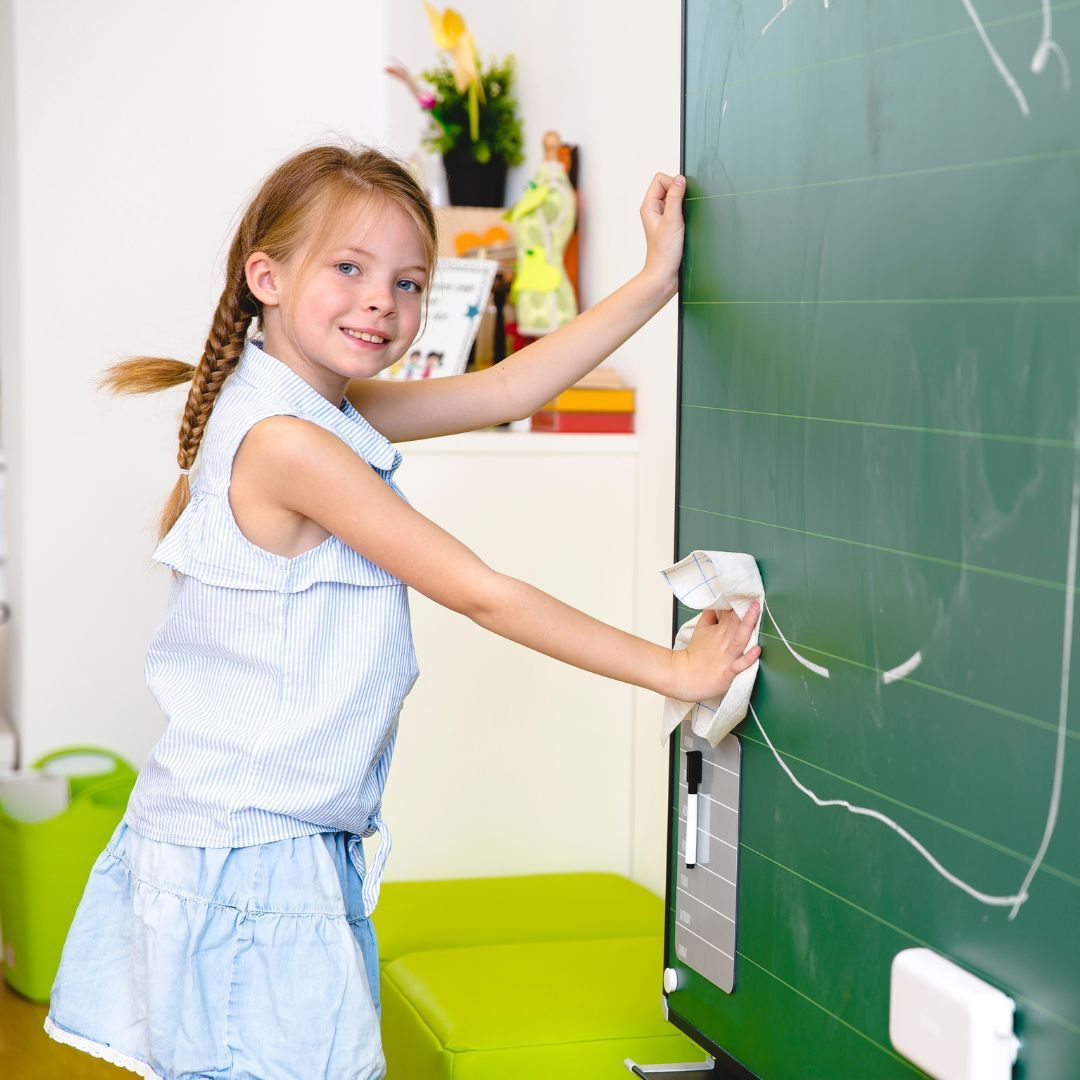 A student cleans the board in a classroom.