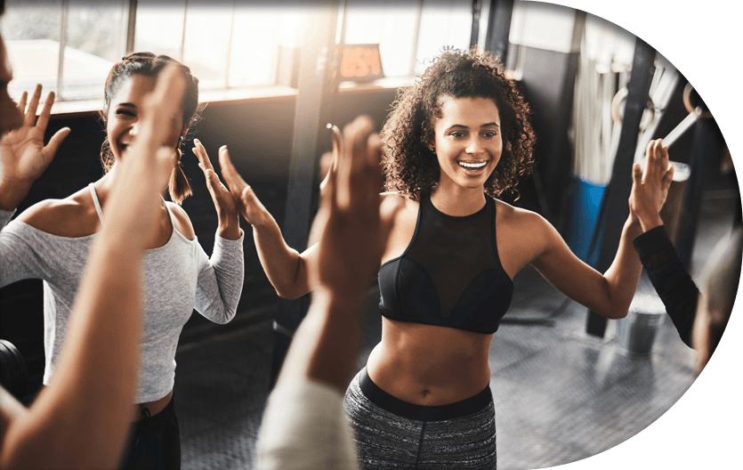 Gym members and instructors smiling in clean gym