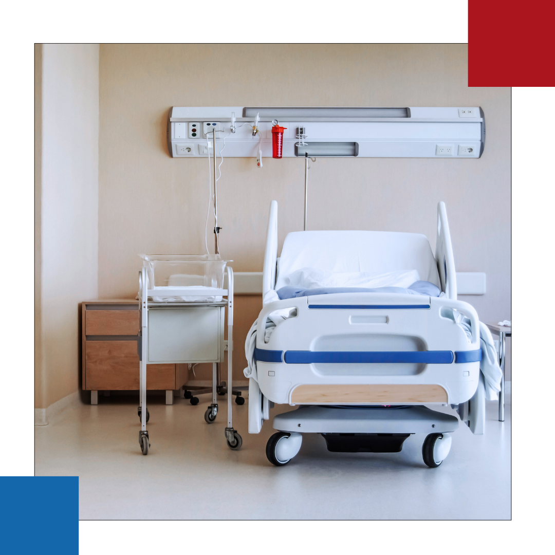 An empty hospital room with a bed and a cart.