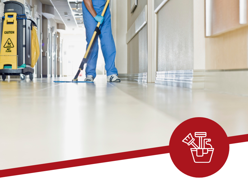 A man is mopping the floor in a hospital hallway