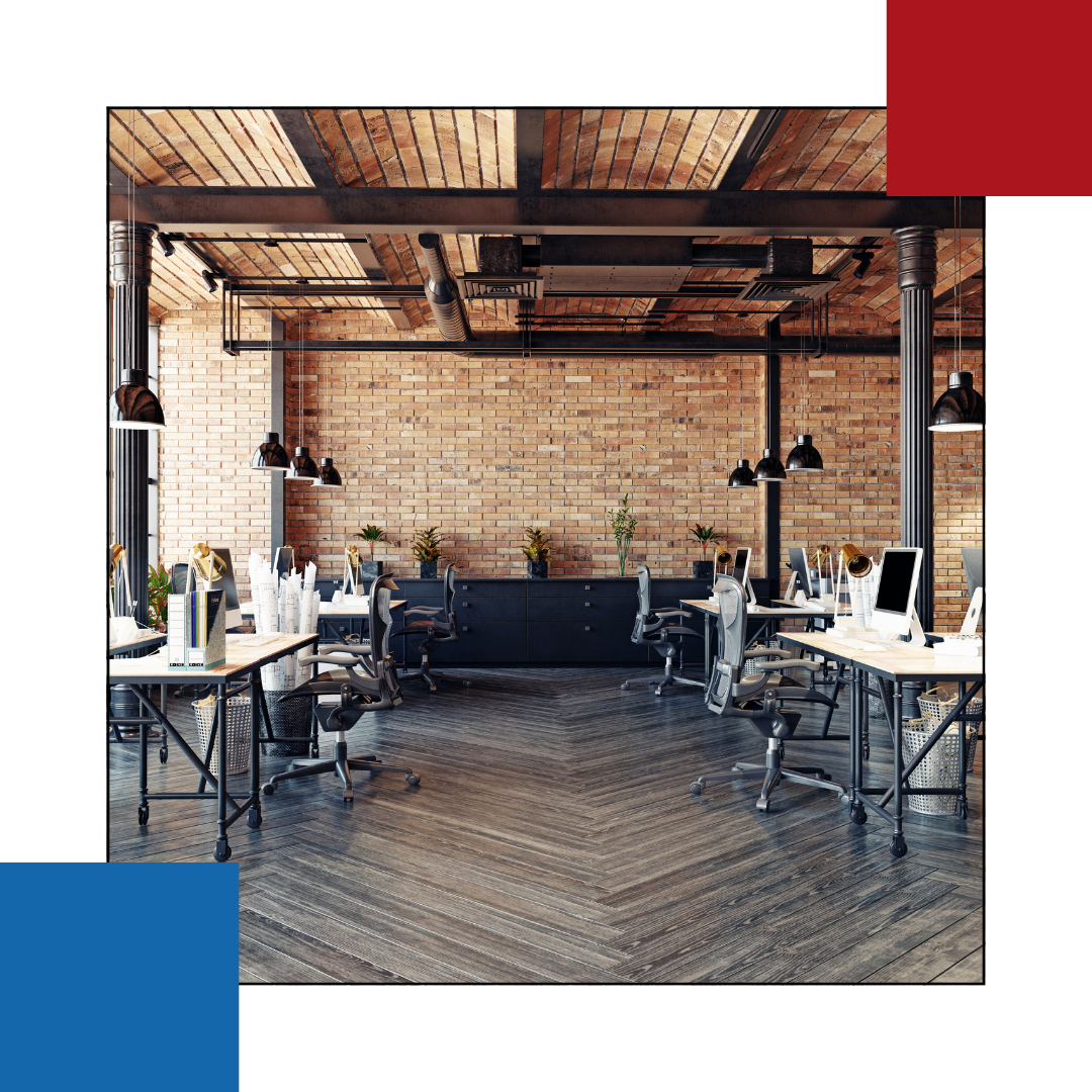 An empty office with tables and chairs and a brick wall.