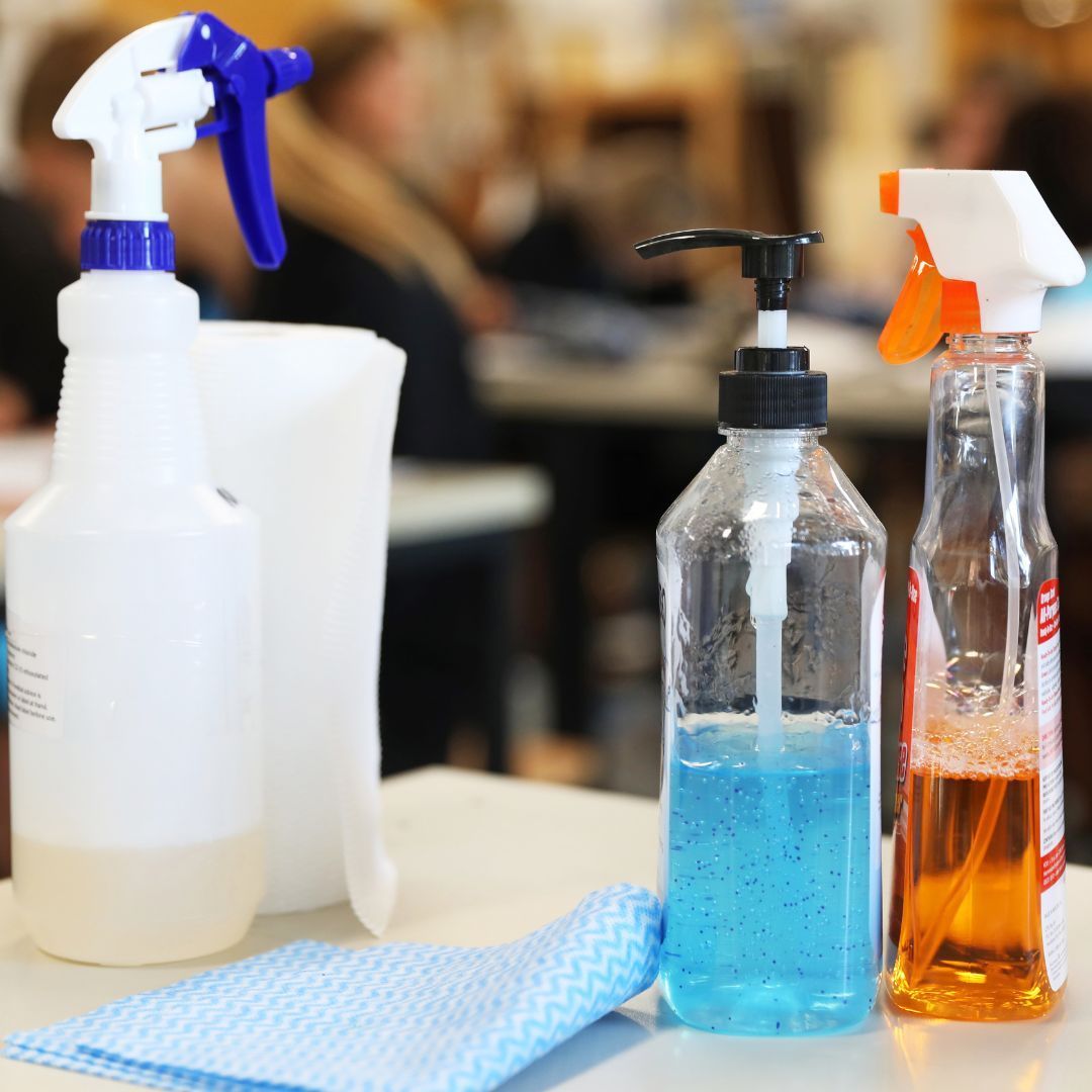 Cleaning supplies on a desk in a classroom